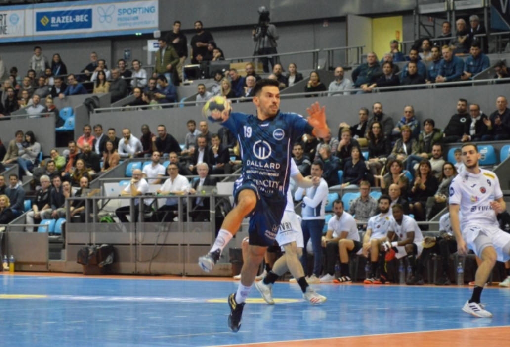 Joueur du Fenix Toulouse Handball en pleine action devant les tribunes du Palais des sports