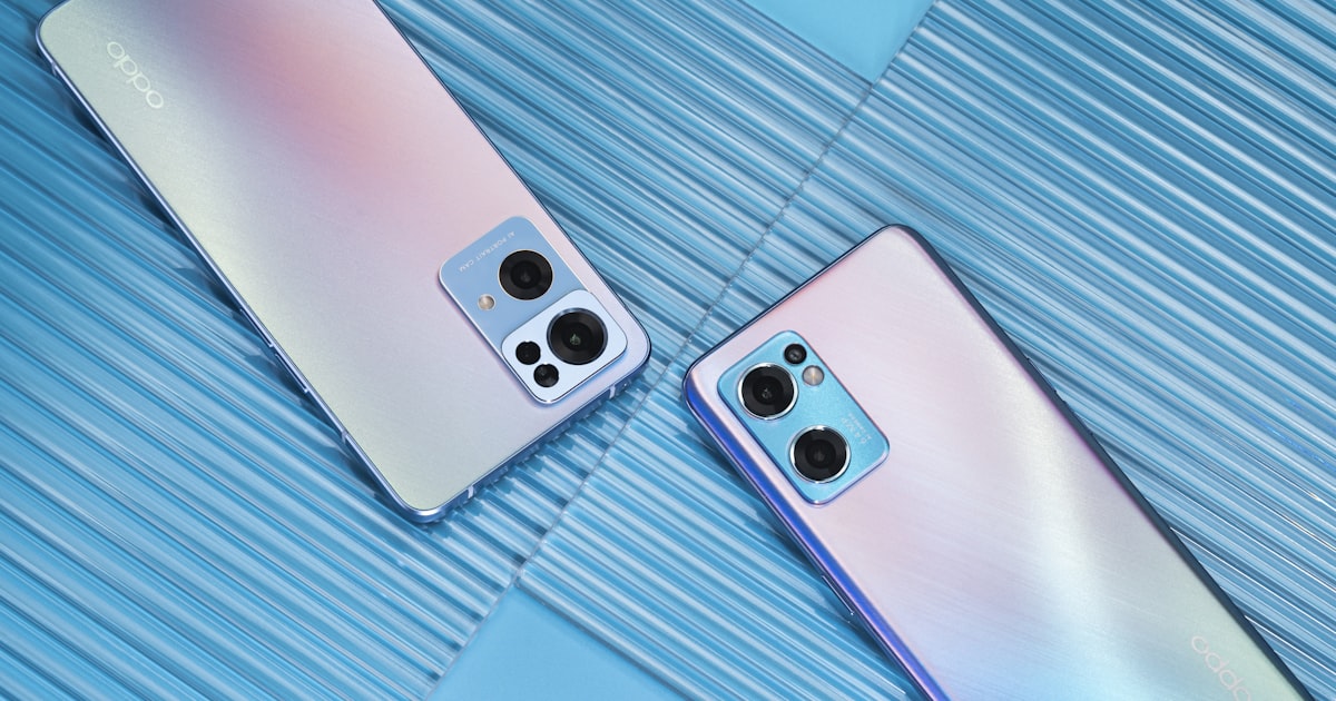 Two smartphones lying side by side, representing a head-to-head comparison of money apps.