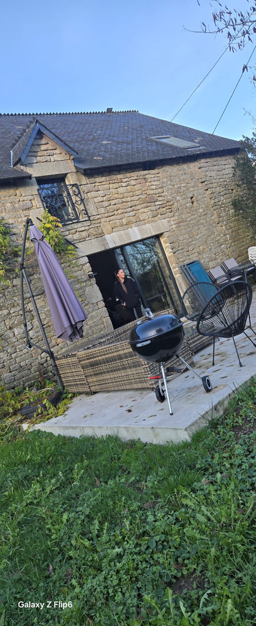 A woman in motion during a yoga session in a light-filled modern room with large windows, wood floors