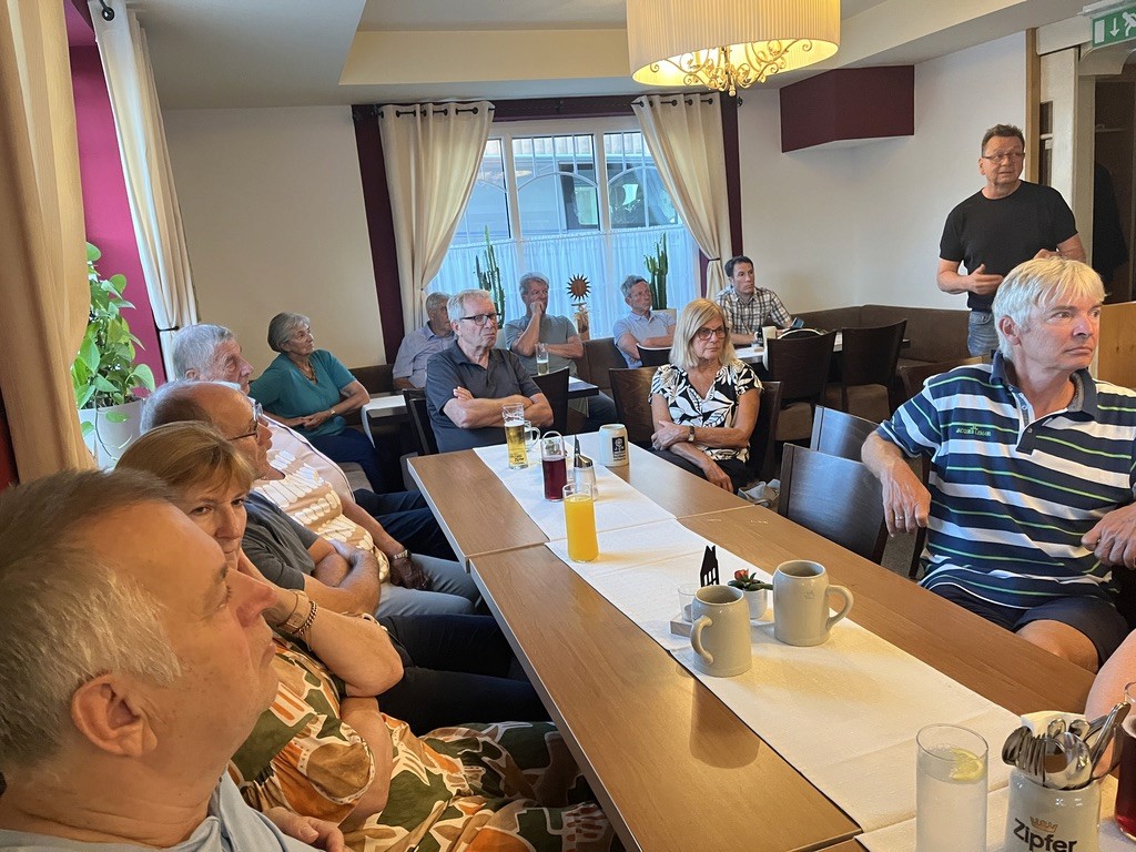 Die Clubmitglieder sitzen bei einem Vortrag beisammen.. 