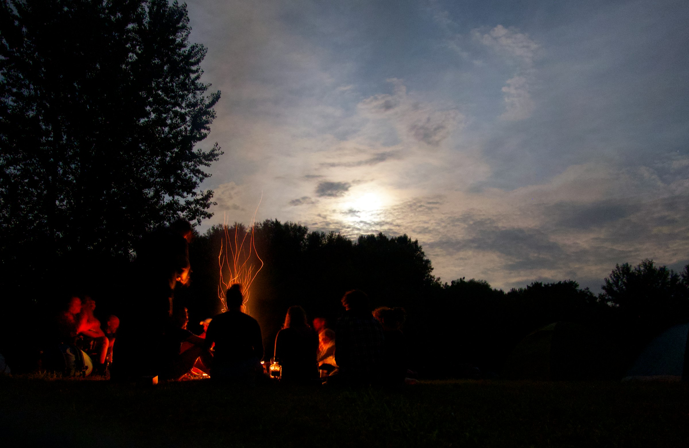 People gathered on a field at sunset