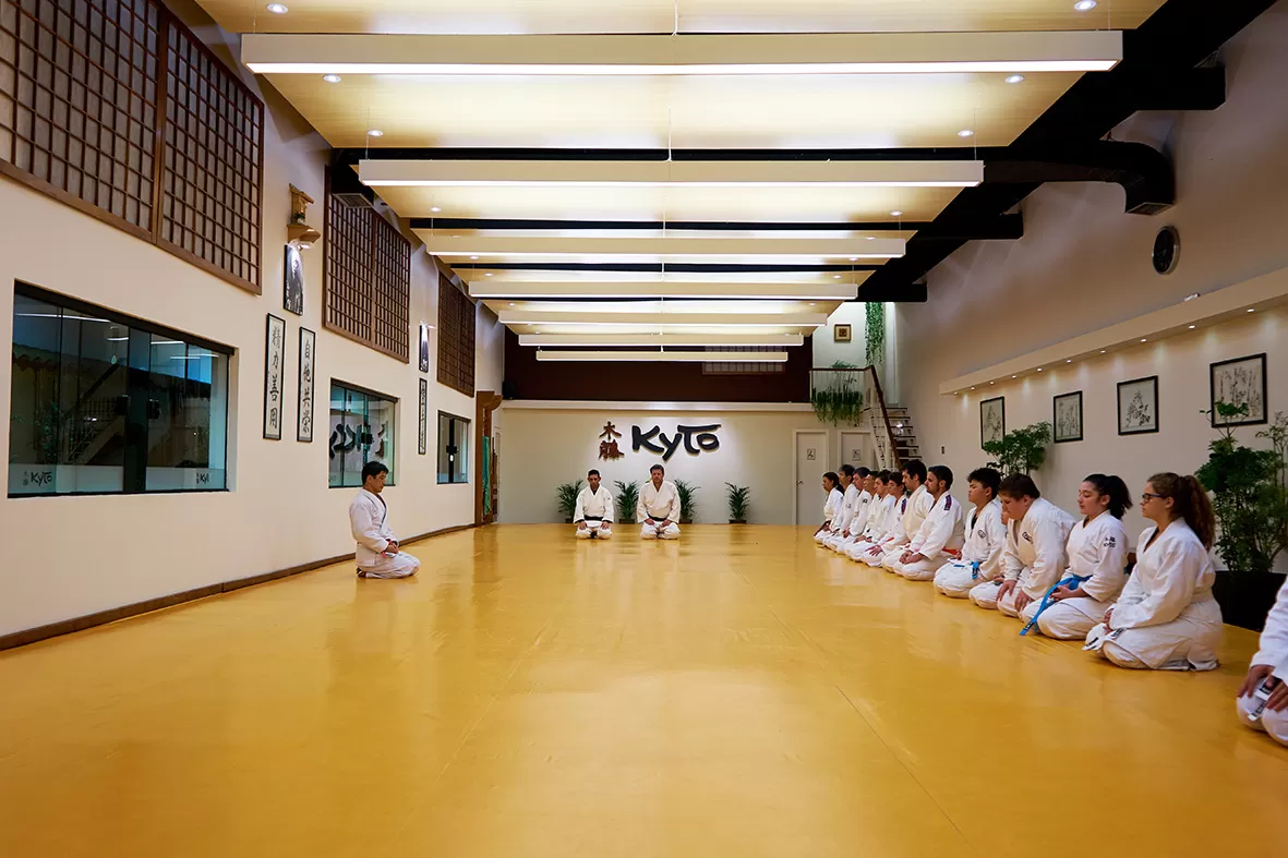 Martial arts students sitting together on the training mat during a class at Rai Martial Arts.