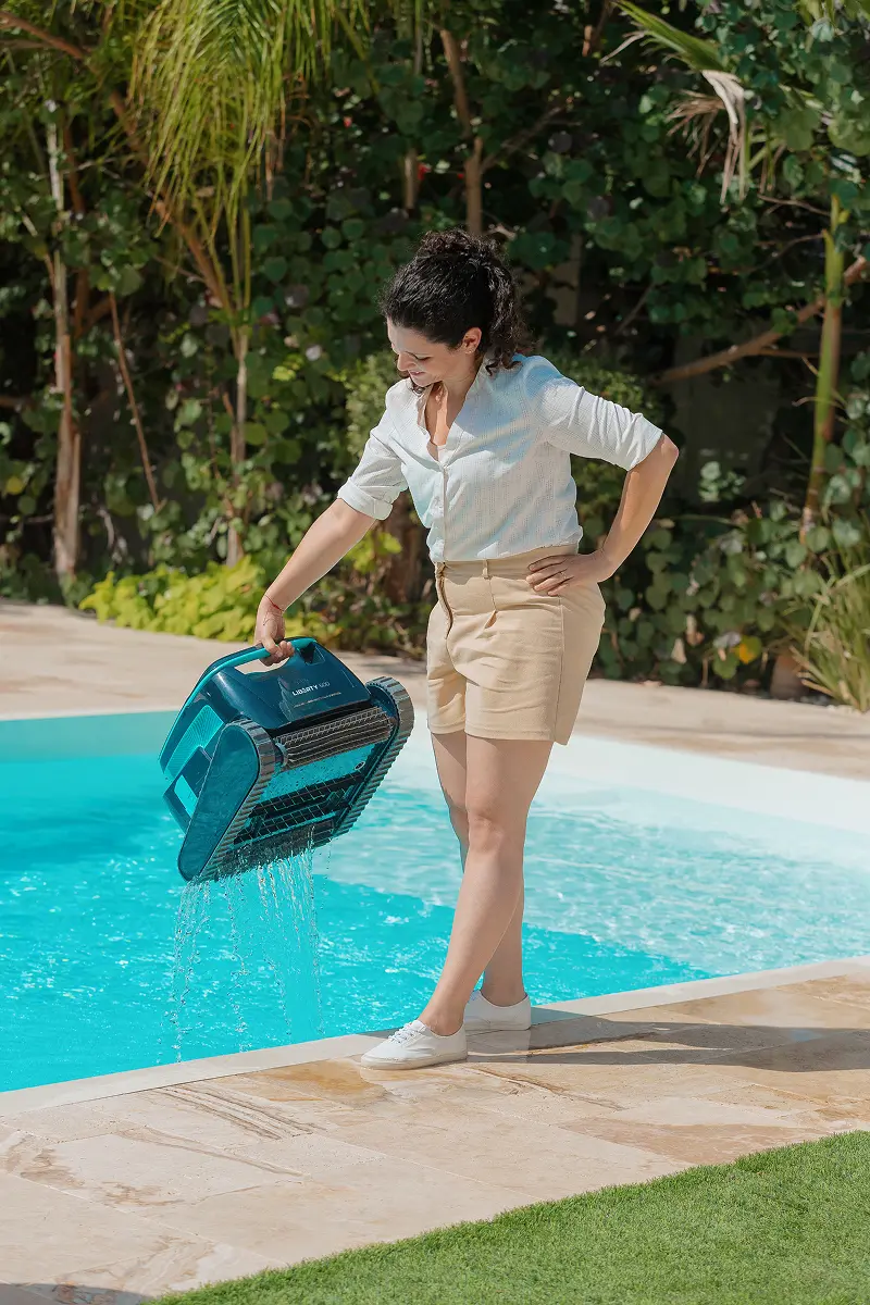 A happy lady in the sun taking her m600 pool cleaner out of the pool