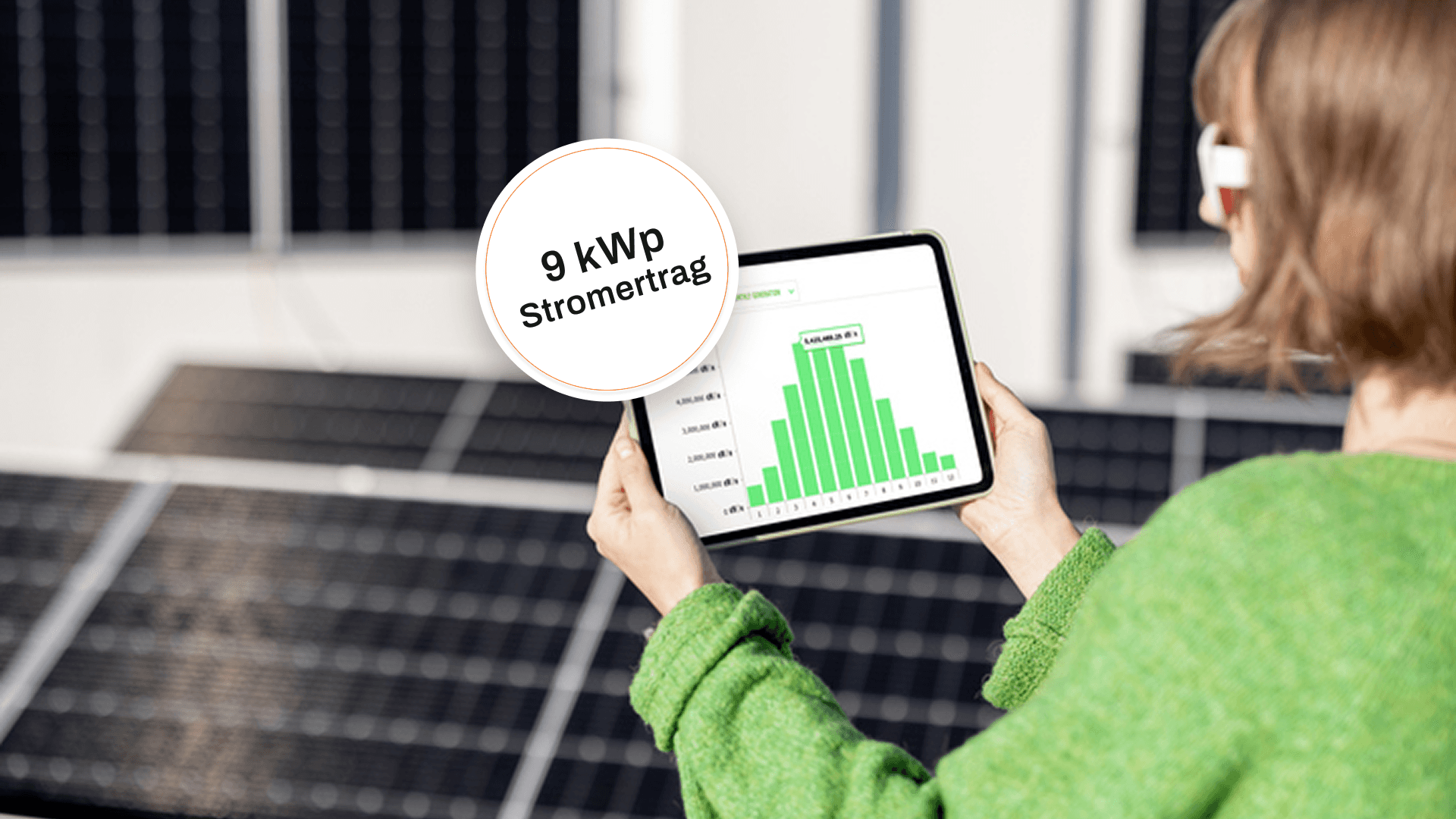 Eine Person hält ein Tablet, das ein grünes Diagramm anzeigt, während sie in der Nähe von Solarpaneelen steht.