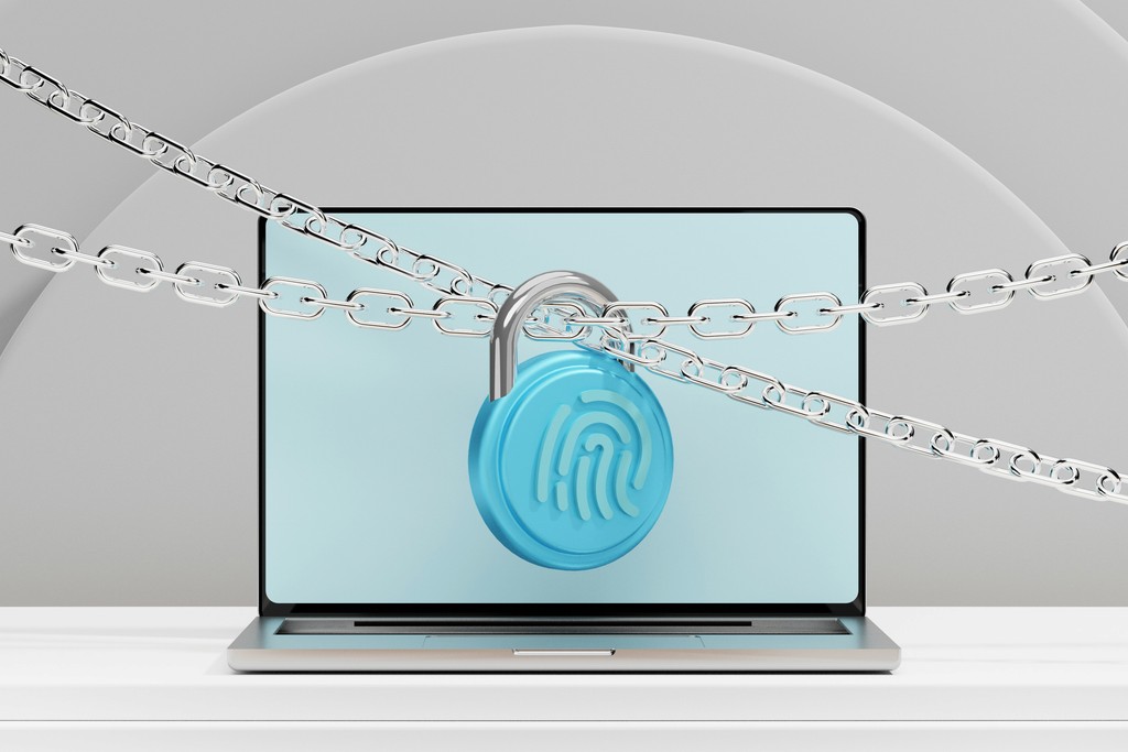 A laptop is secured with a chain and padlock featuring a fingerprint symbol, representing cybersecurity and data protection. The image highlights the importance of safeguarding personal and sensitive information in the digital age.