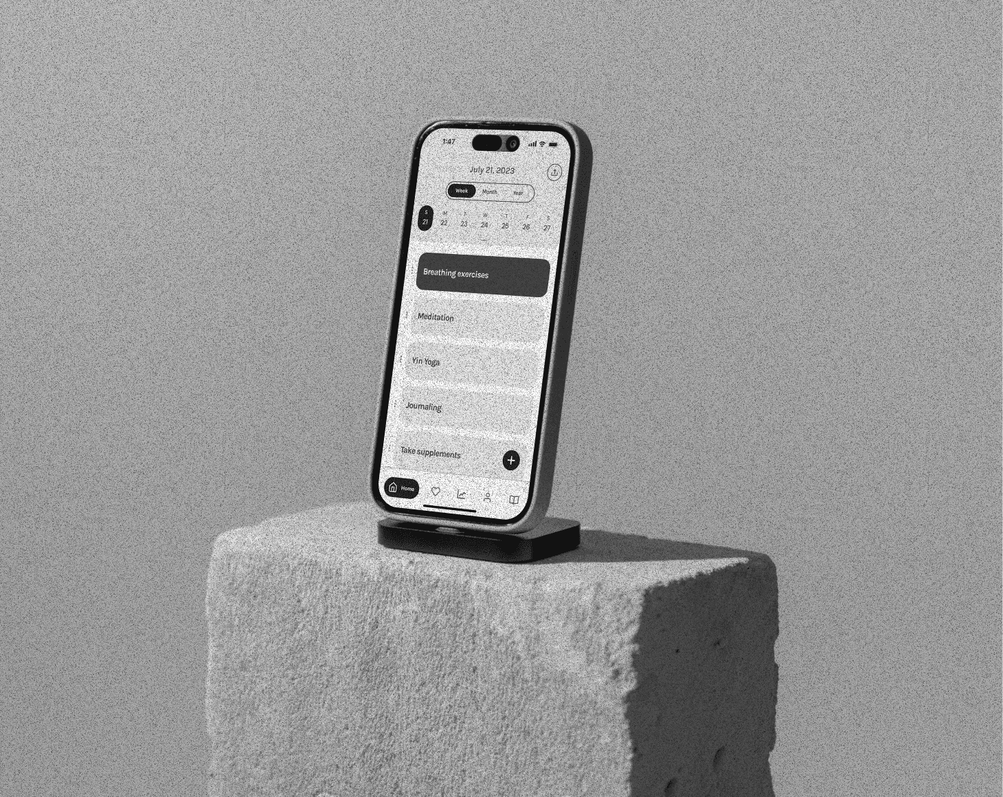 Iphone sitting up-right on a concrete block with a greyscale filter