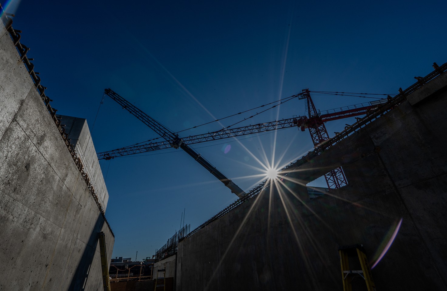 Un employé décape un meuble en bois à l'aide d'une ponceuse.