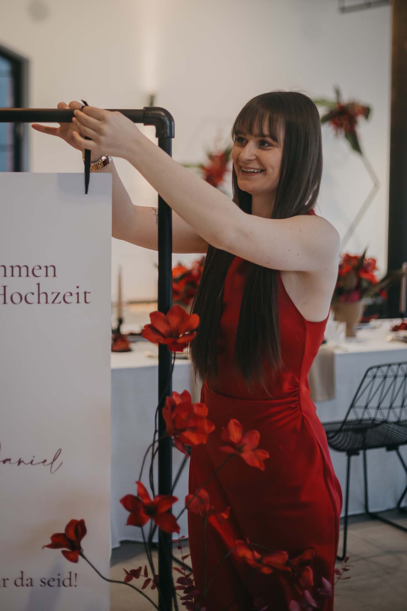 Hochzeitsplanerin Emily richtet die Schleife am Sitzplan.