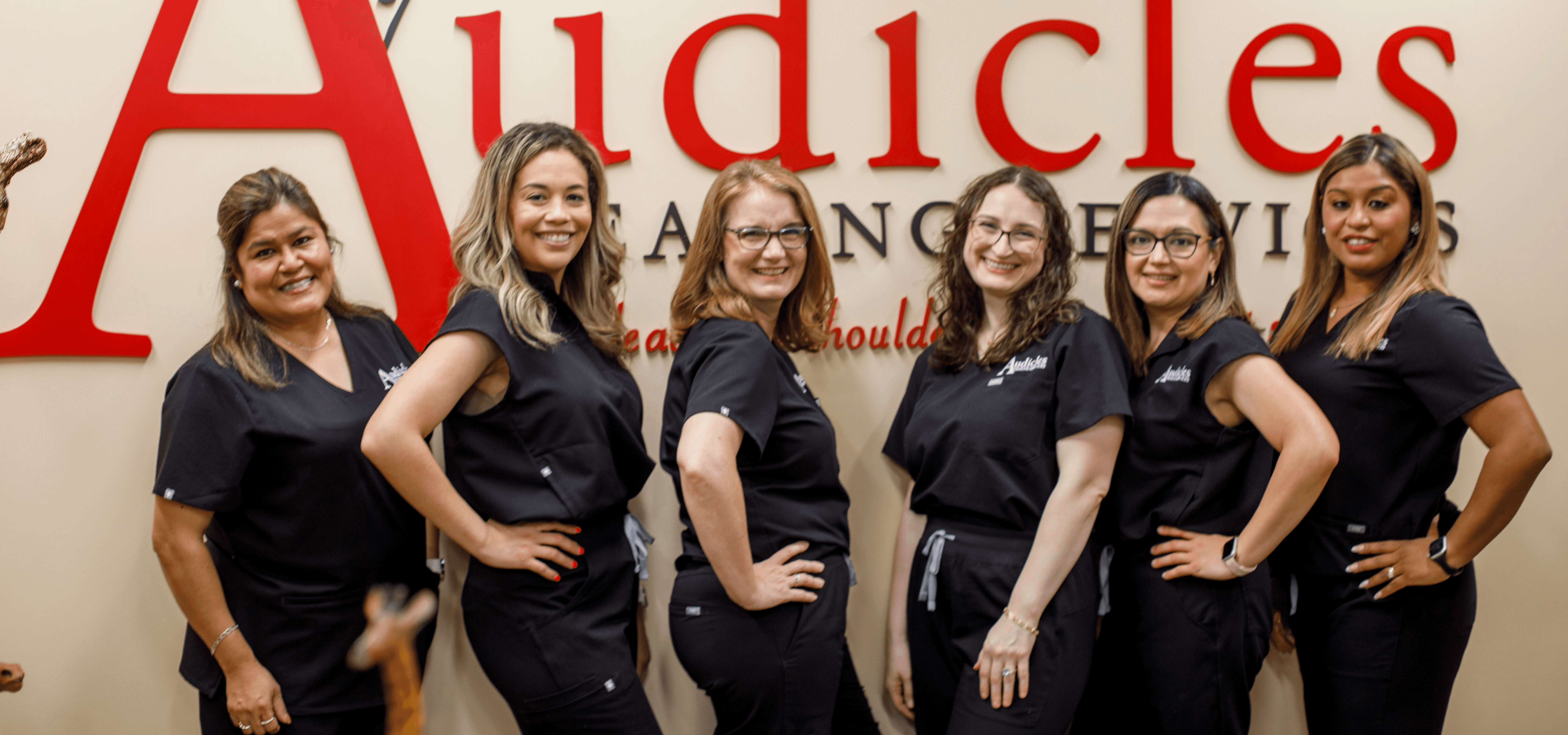 The audicles team in front of the Name Sign