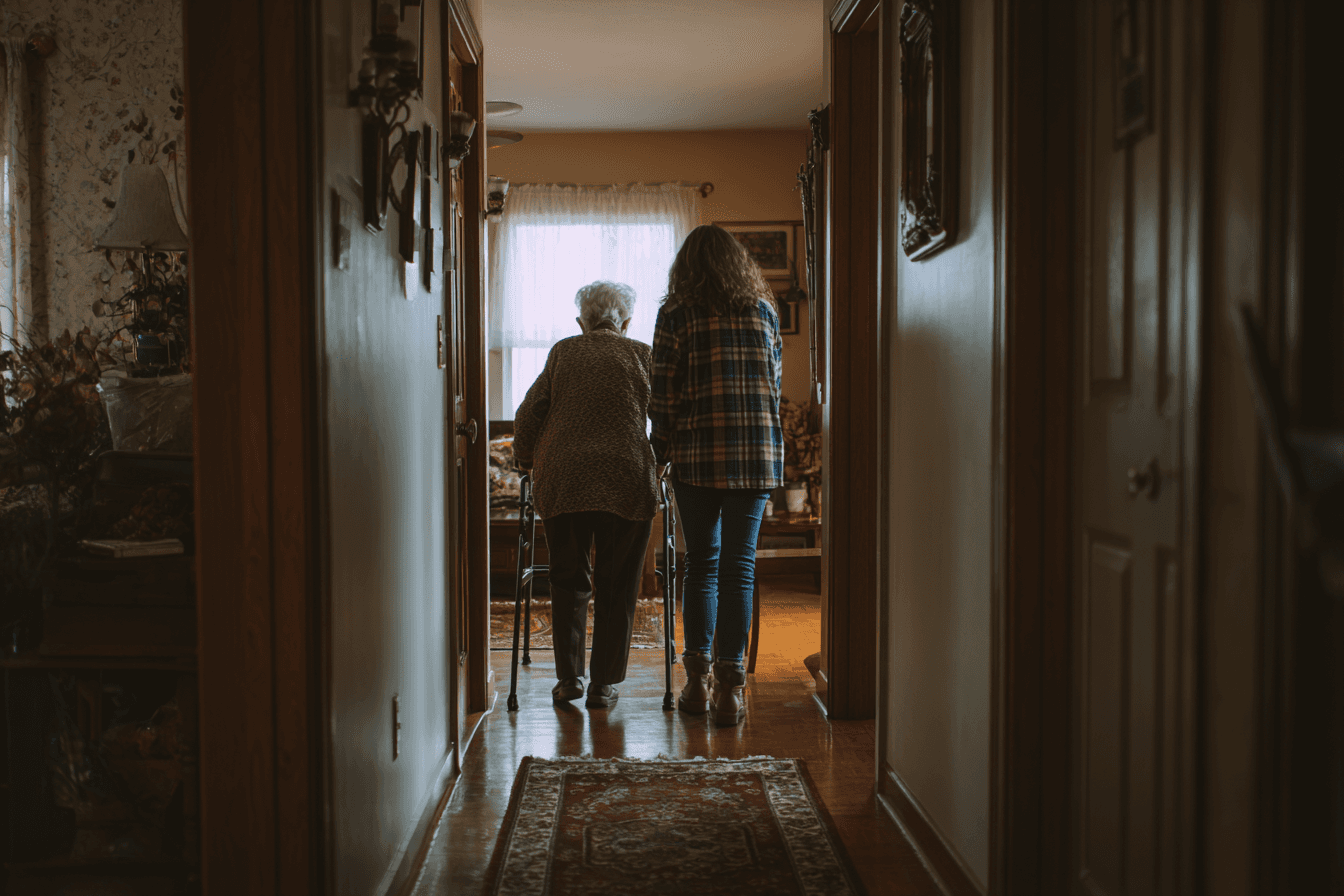 a senior walking with the assistance of a caregiver in her home.