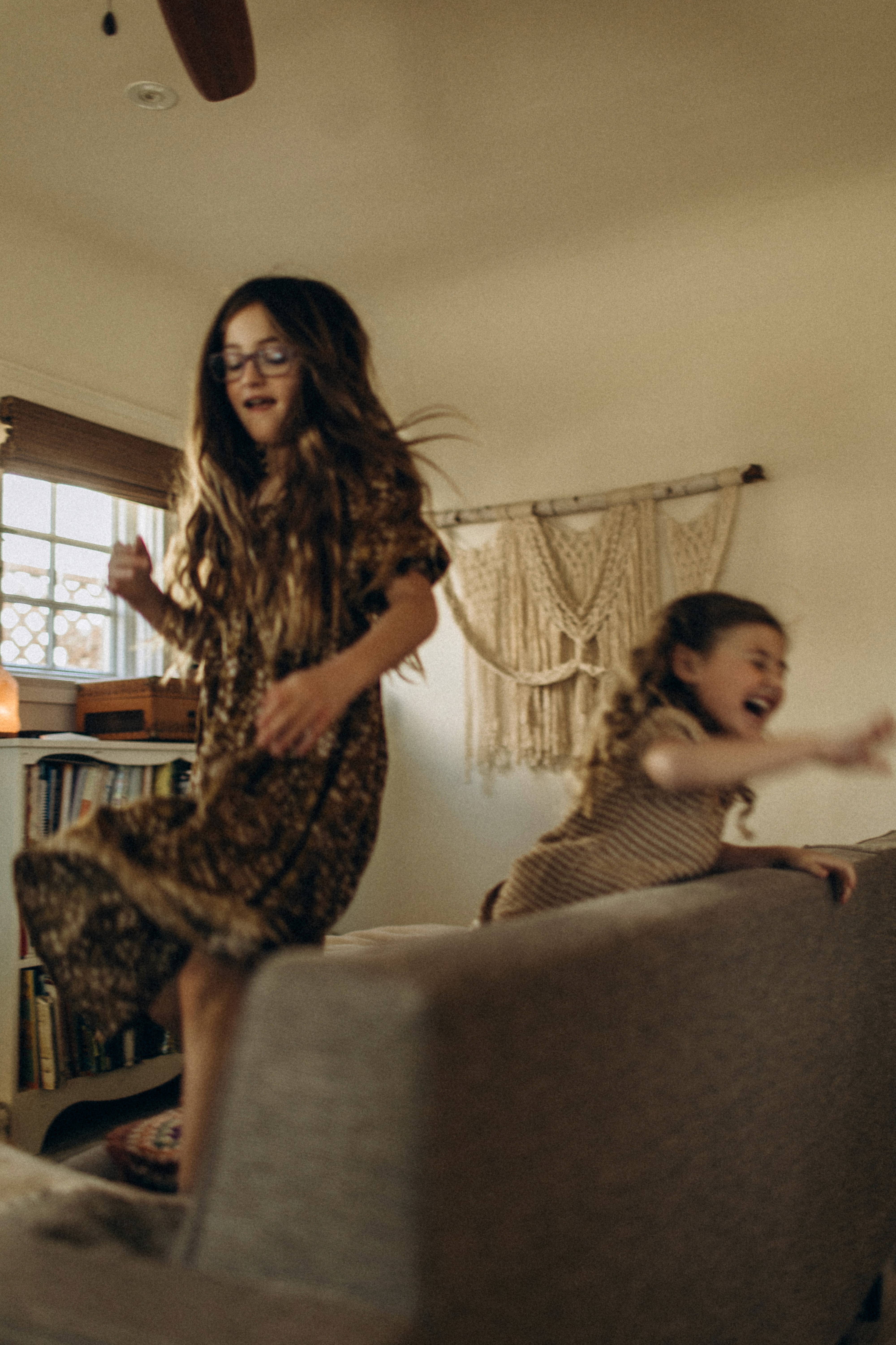 Sisters playing together on the couch during a relaxed in-home lifestyle session