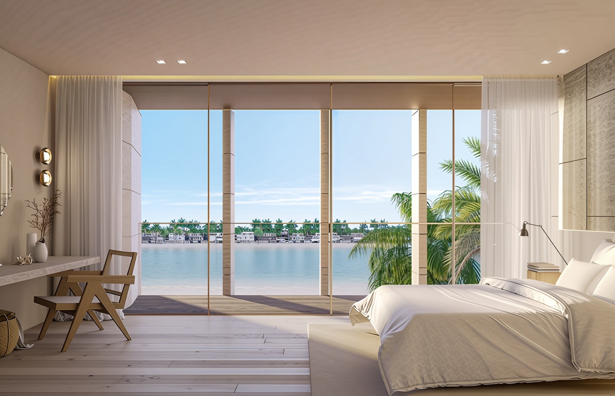 A serene bedroom featuring a view of the ocean and beach, surrounded by lush garden homes.