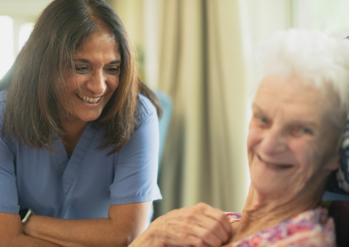 Nurse smiling with an older participant at home