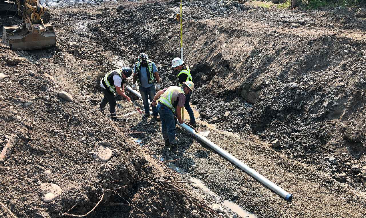Construction crew installing dewatering infrastructure under SweetTech engineering supervision at Elbow River gauge station site