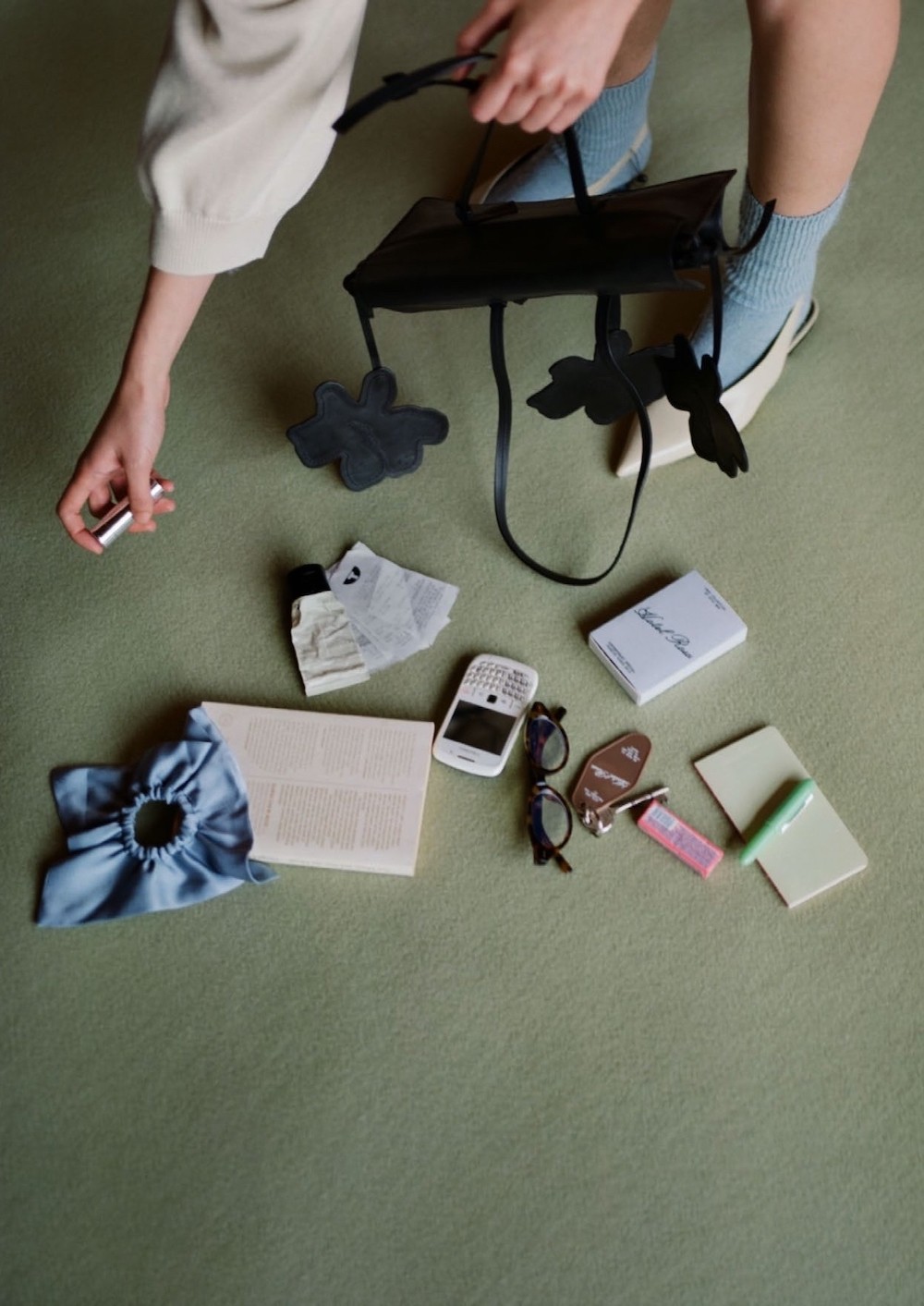 Nature morte d'objets sur le sol que ramasse la mannequin du lookbookRita Row