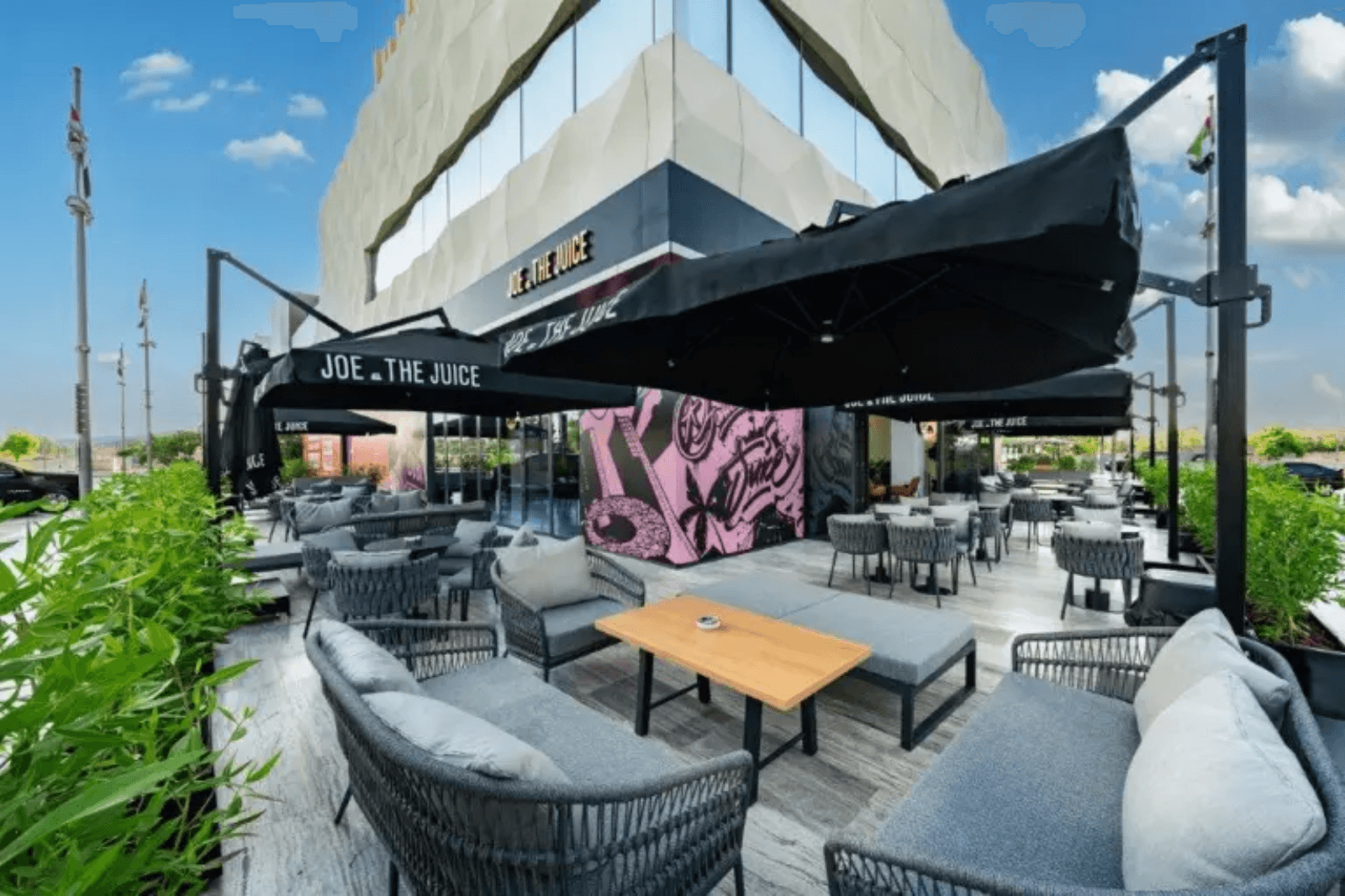 Stylish outdoor seating area at Joe & The Juice cafe with modern lounge chairs.