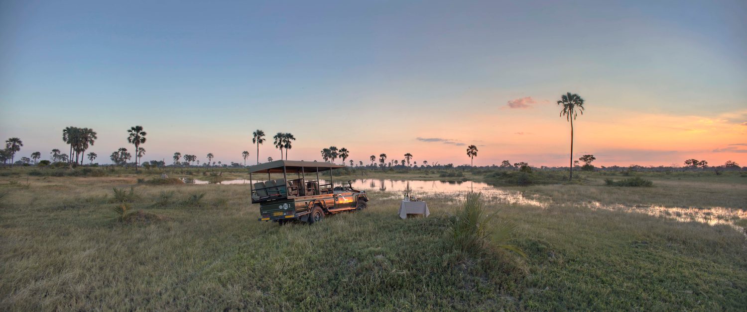 Sundowners set beside the game-drive vehicle at the river as the sun goes down