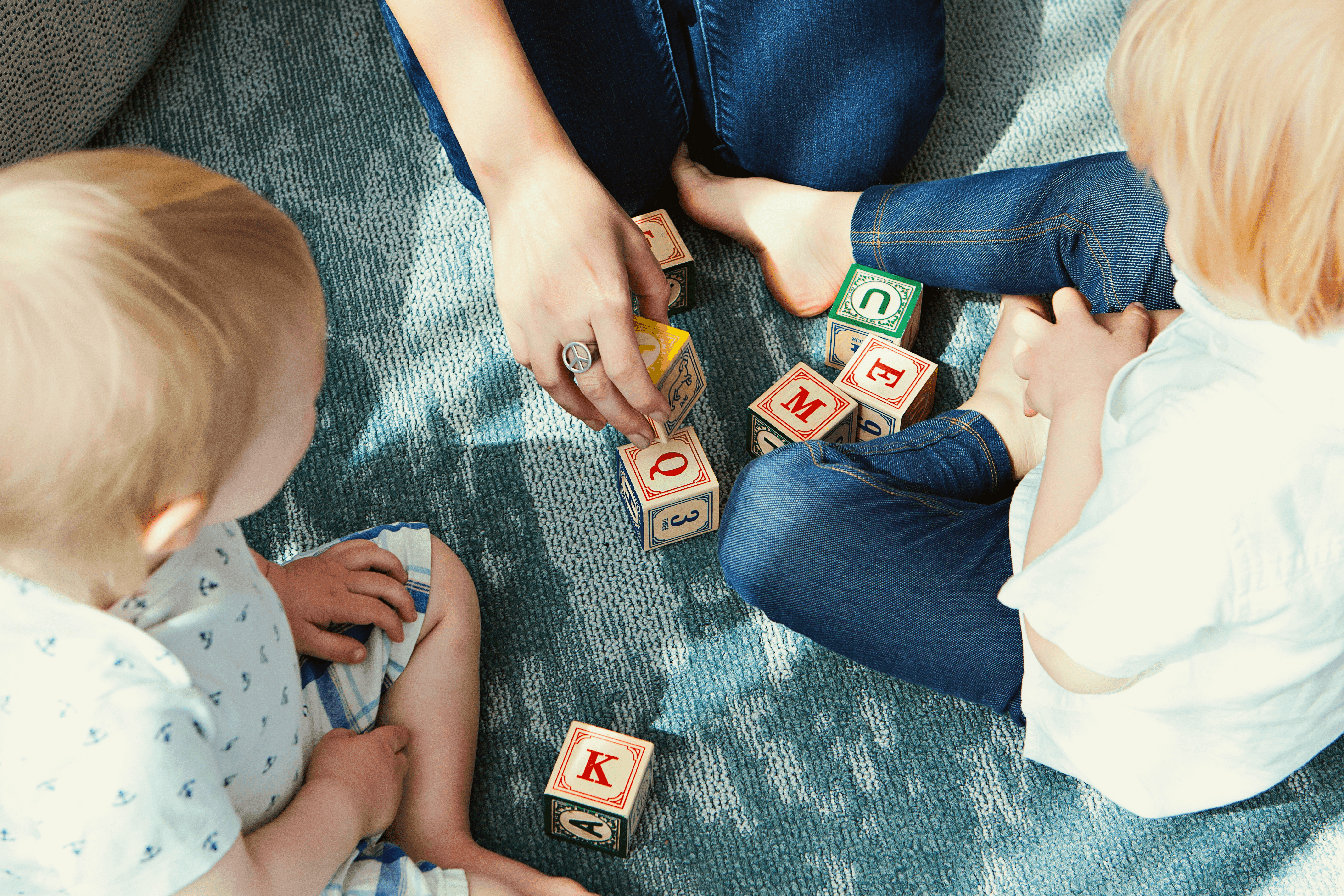 two toddler playing letter cubes
