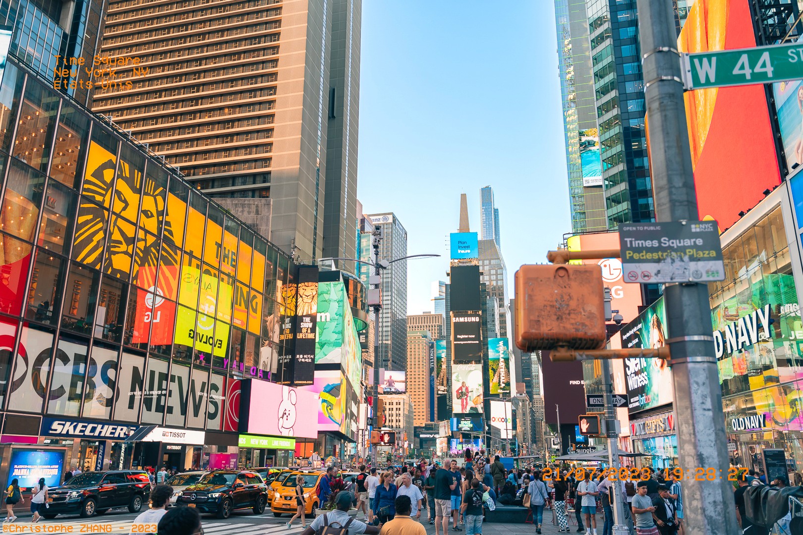 Vue iconique de Times Square, New York, remplie de visiteurs et d'écrans géants publicitaires.