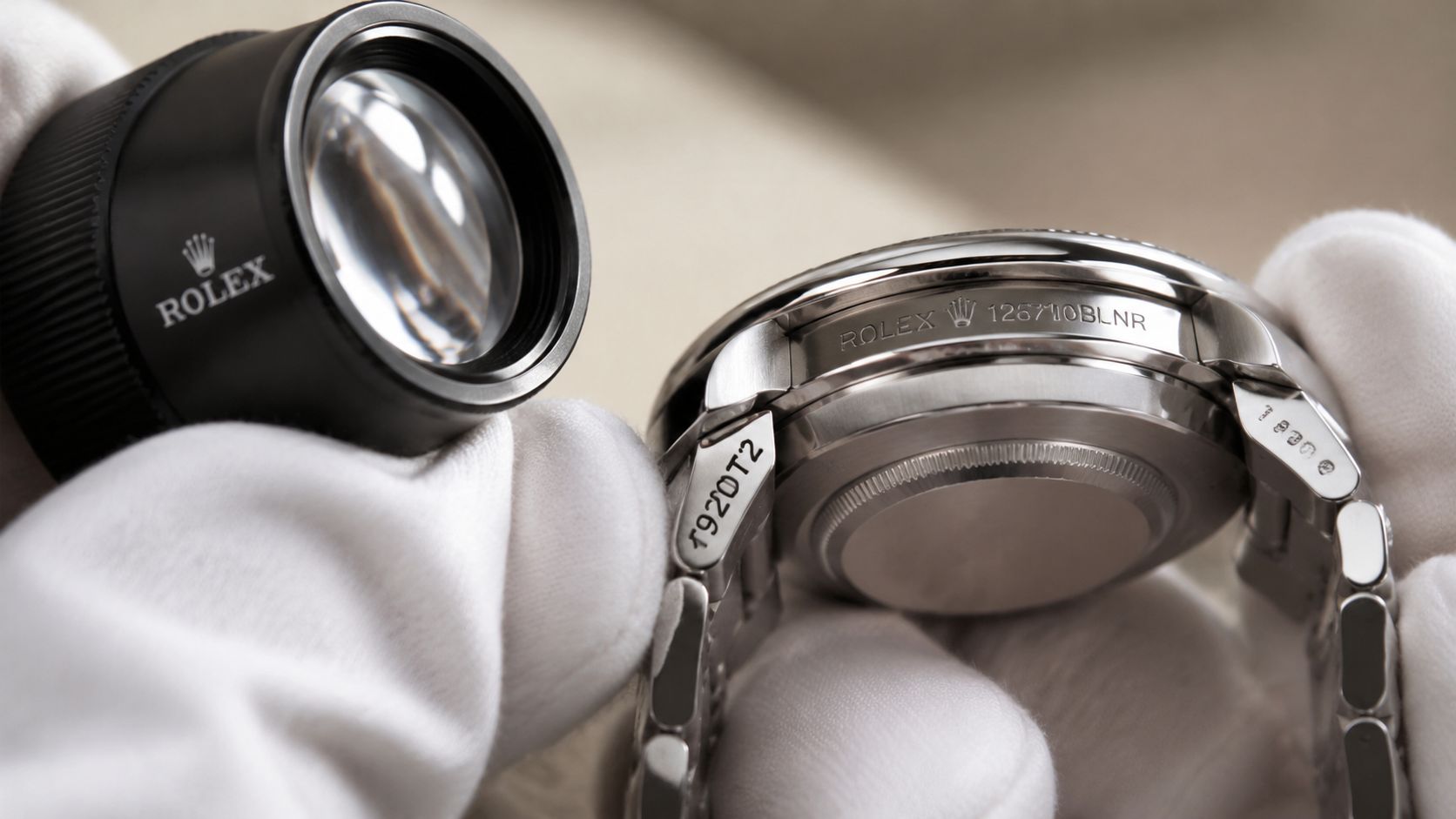 A close-up view of a Rolex watch being inspected with a magnifying jeweler's loupe for authenticity.