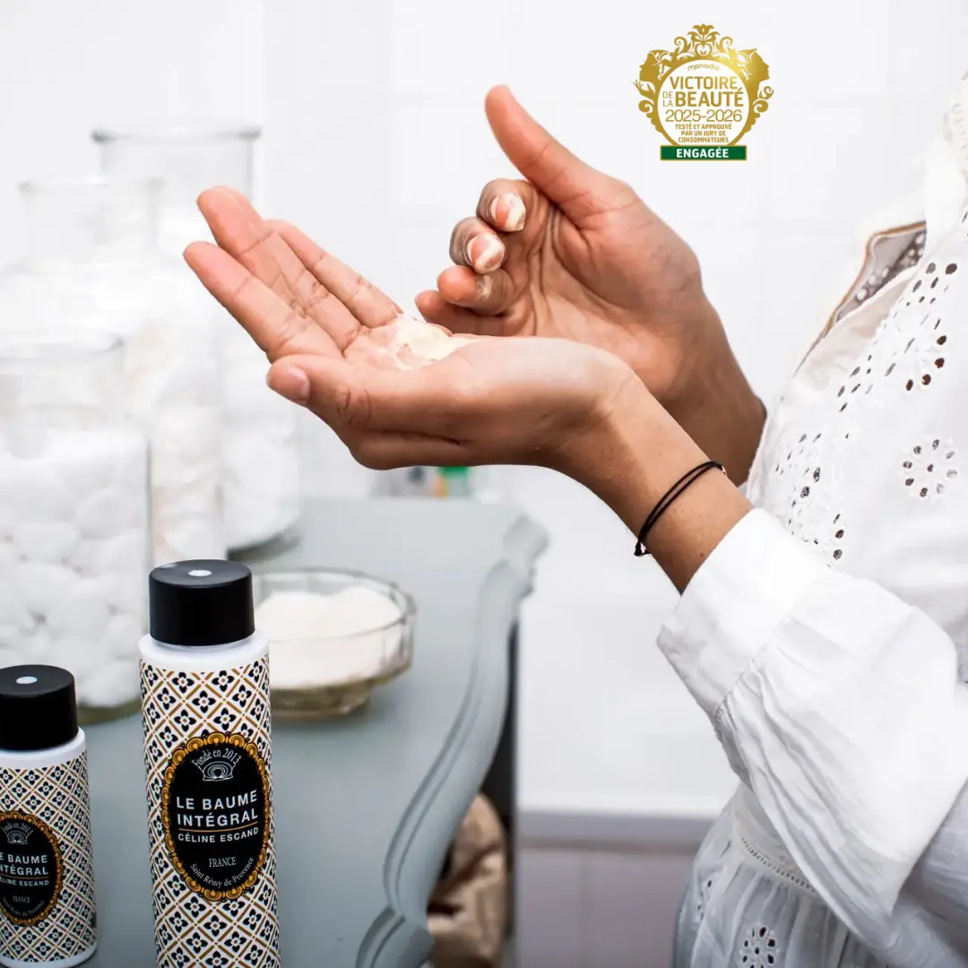 Application du Baume Intégral sur les mains dans un décor de salle de bain