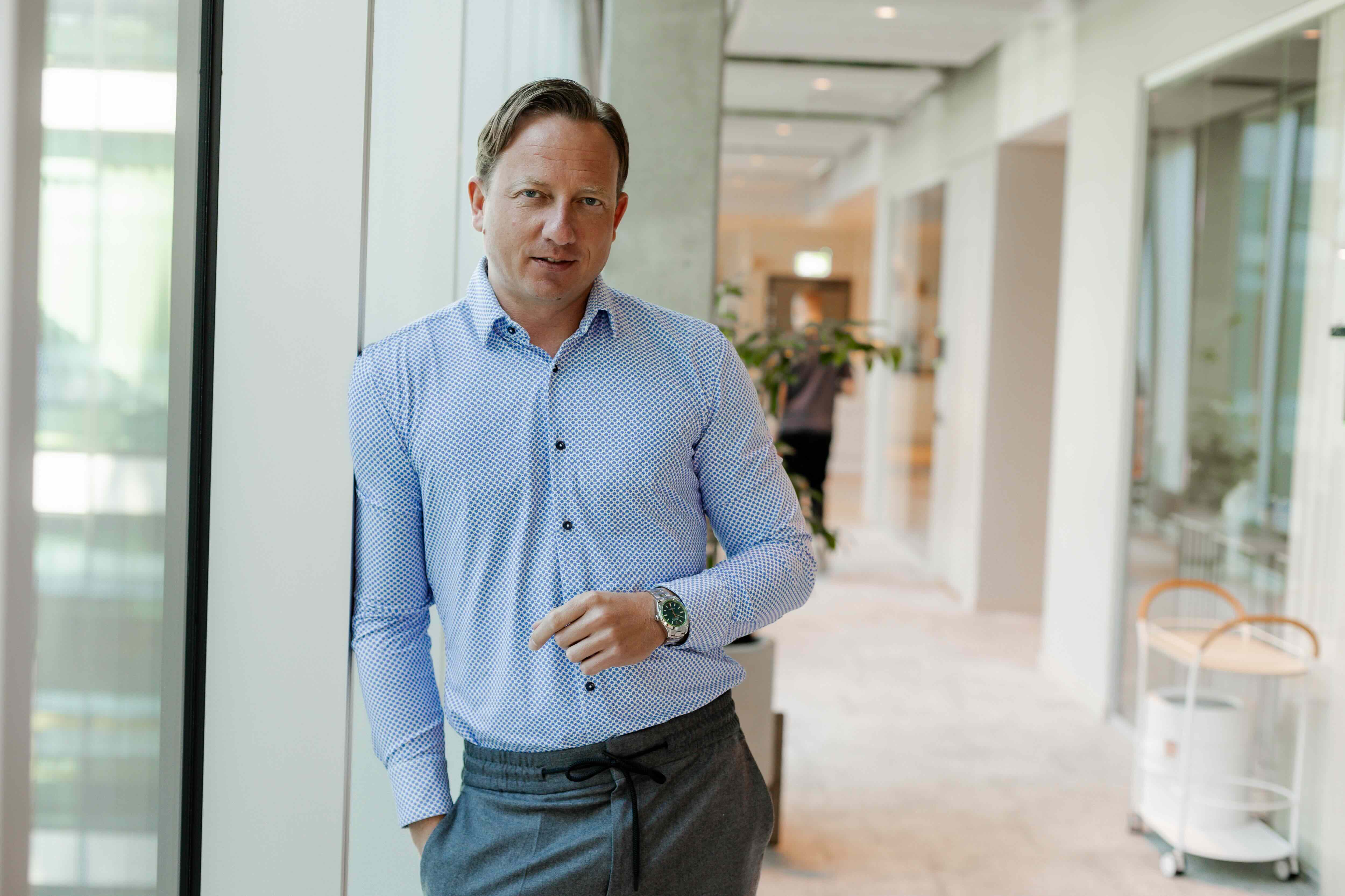 Sebastian Ludwig steht in einem Office am Fenster