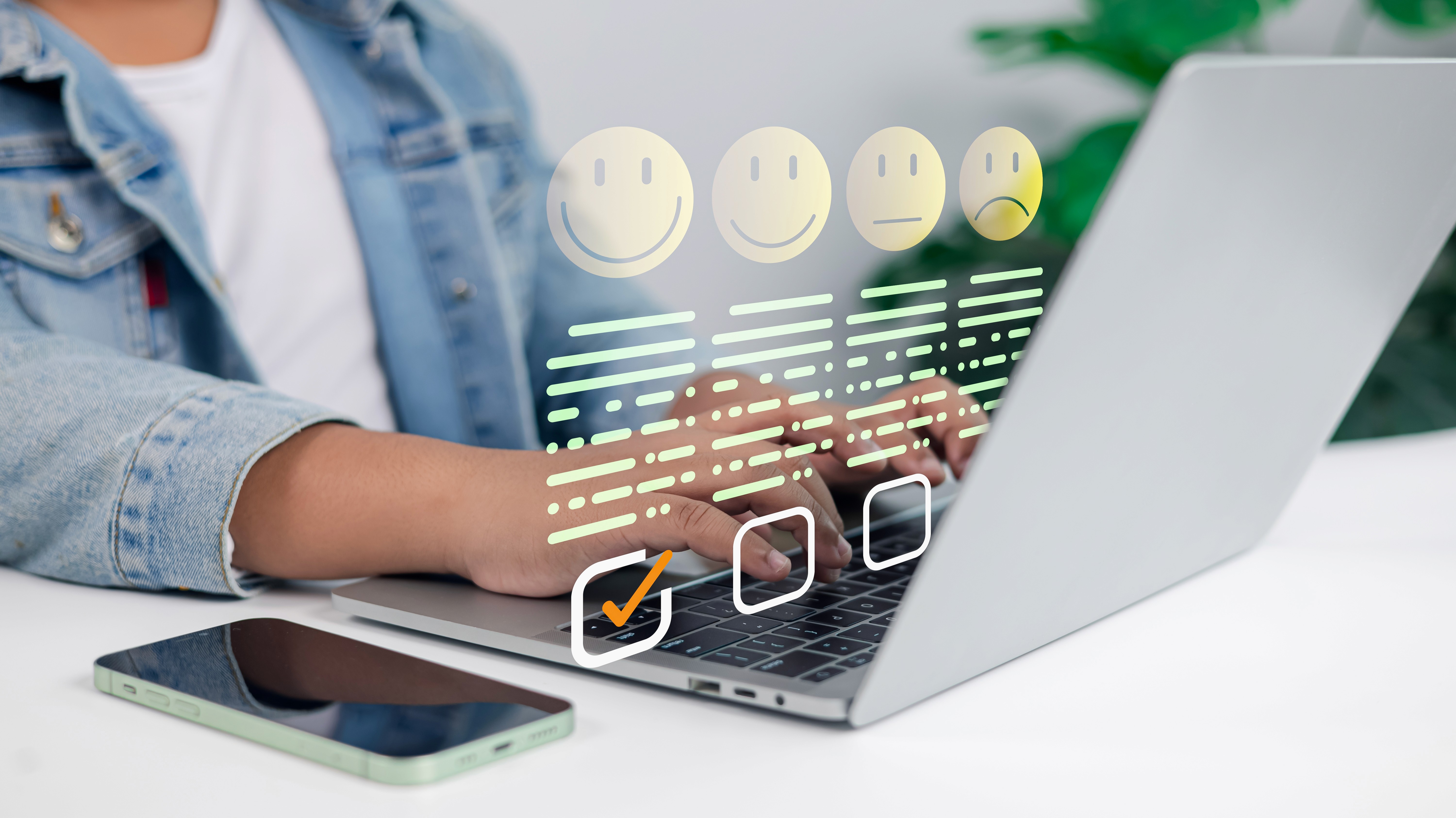 Person tippt auf Laptop mit eingeblendeter Bewertungsskala von lachendem bis traurigem Smiley, erster Smiley ist angekreuzt