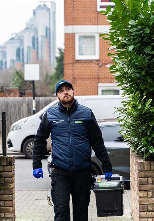 Professional pest control technician arriving at a property for service
