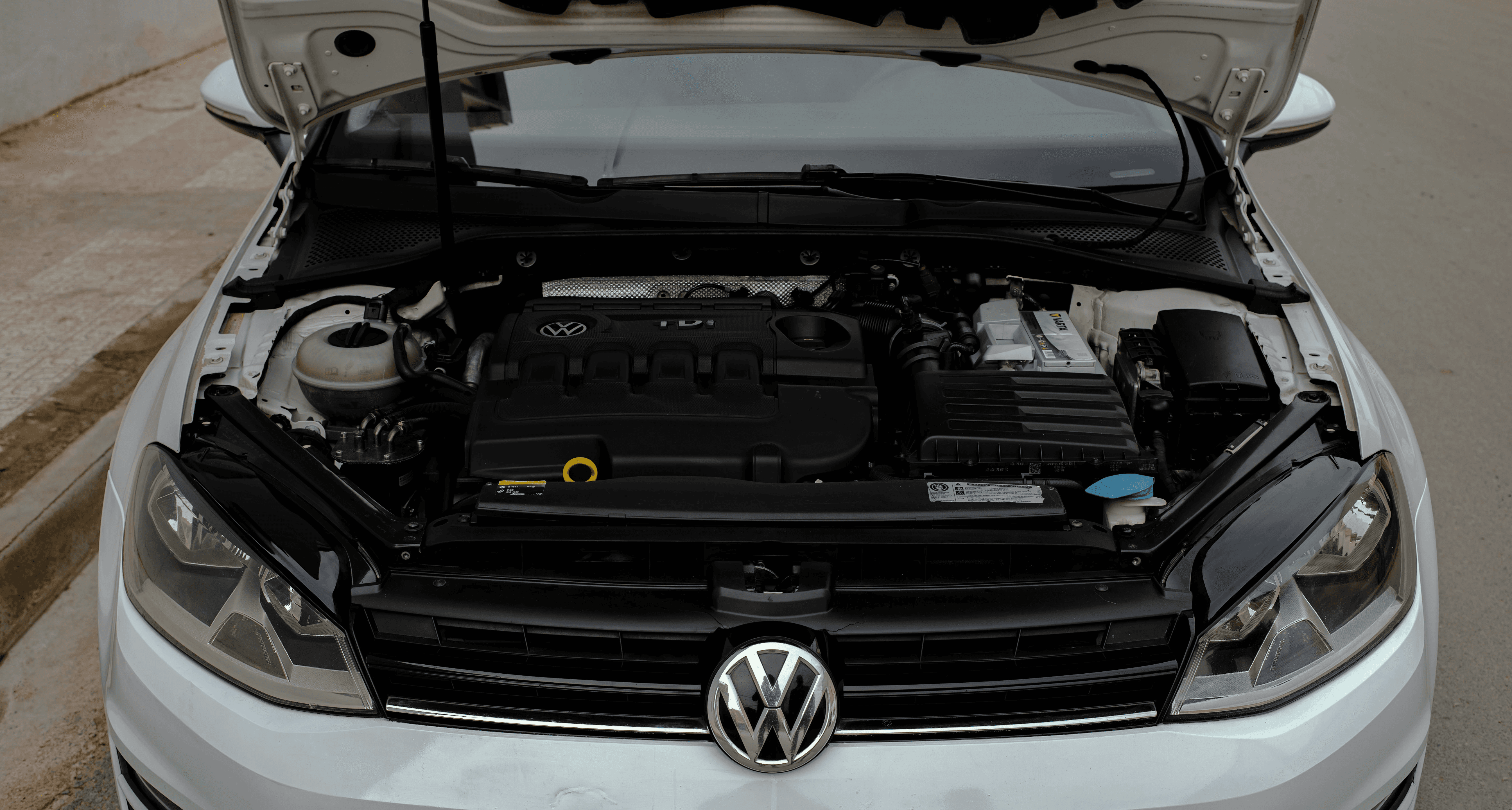 a white volkswagen car with its hood open
