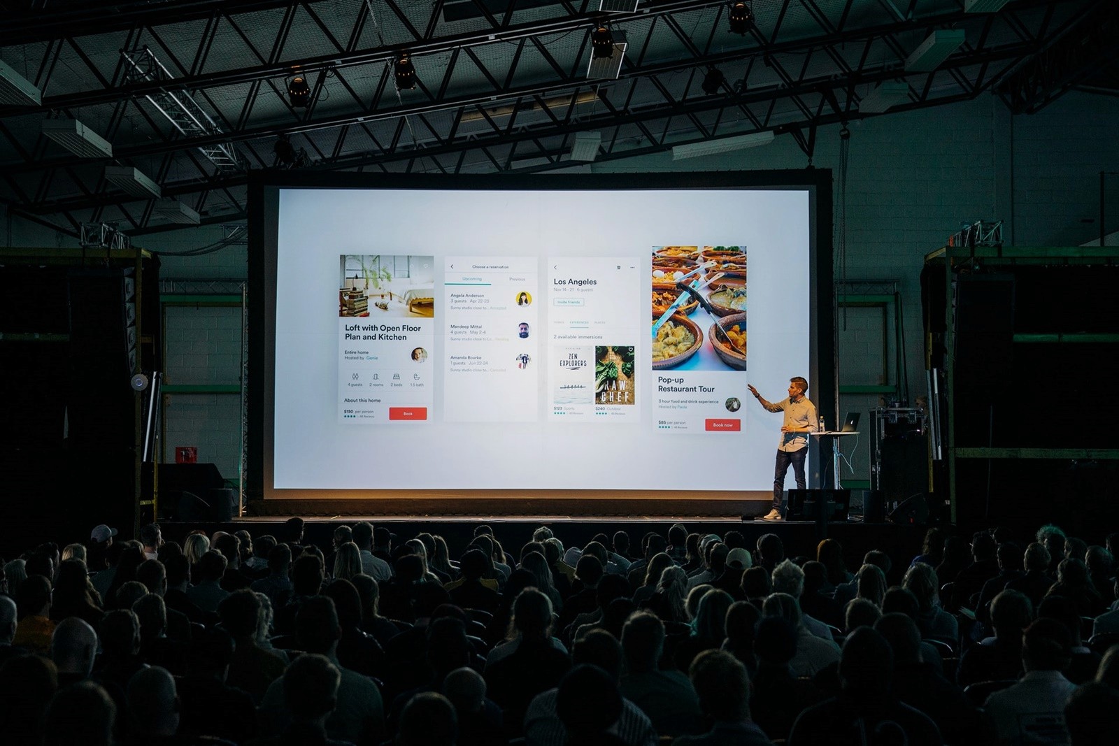 Homem em palco faz apresentação sobre airbnb