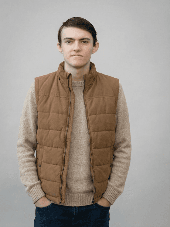 Portrait of a person in a pink sweater against a light background