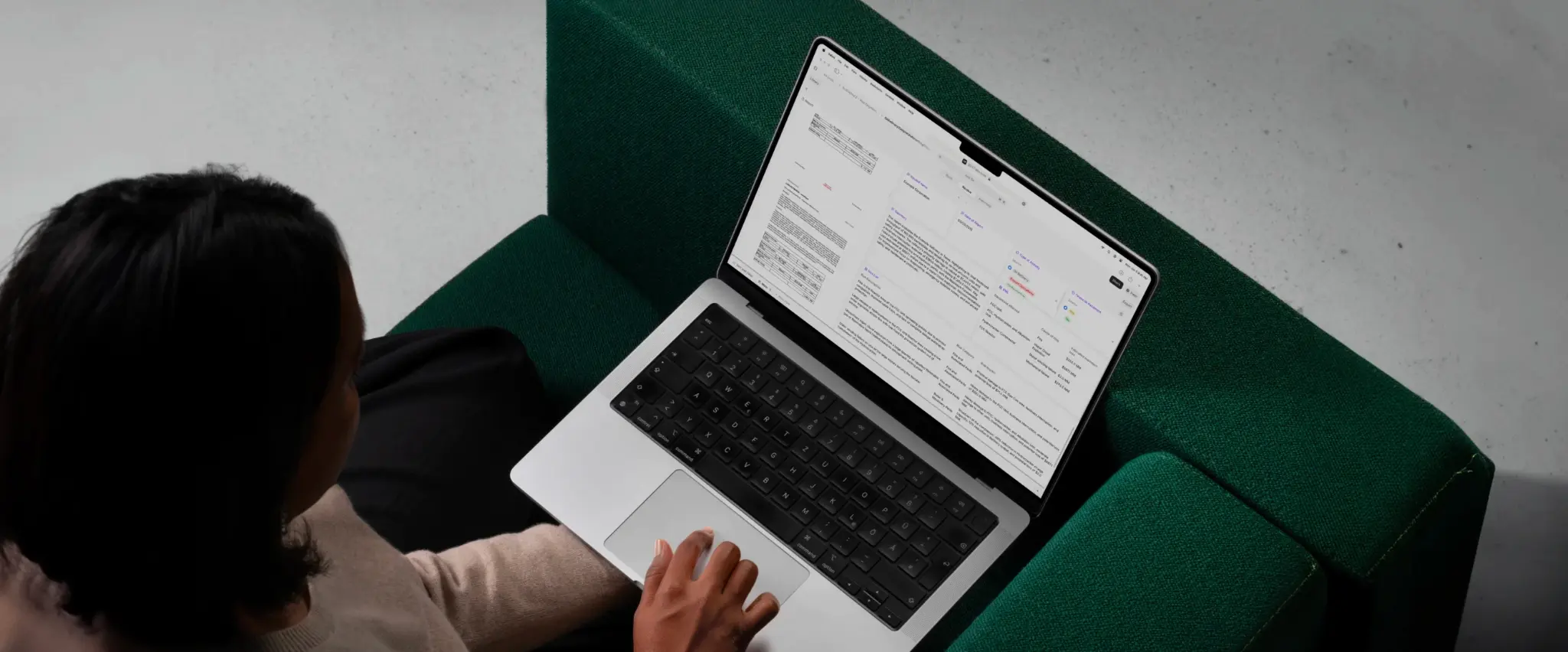 Person using laptop on a green sofa