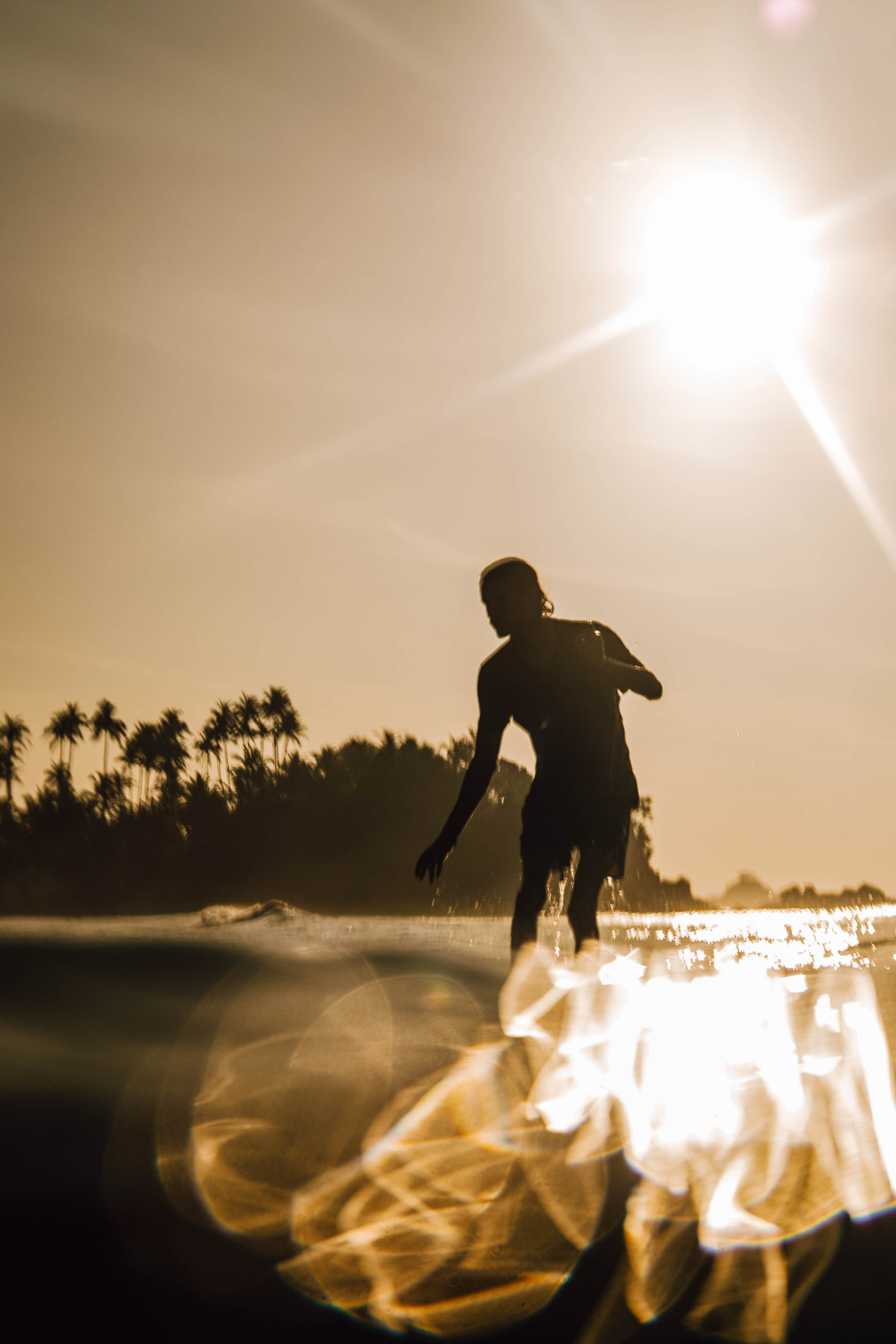 A surfer riding a wave on a surfboard, with a clear blue sky in the background.
