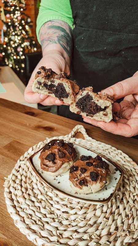 Cafe owner breaking a brownie cookie in half to reveal a gooey chocolate center