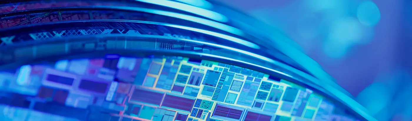 Close-up of a silicon wafer's chip patterns under blue light