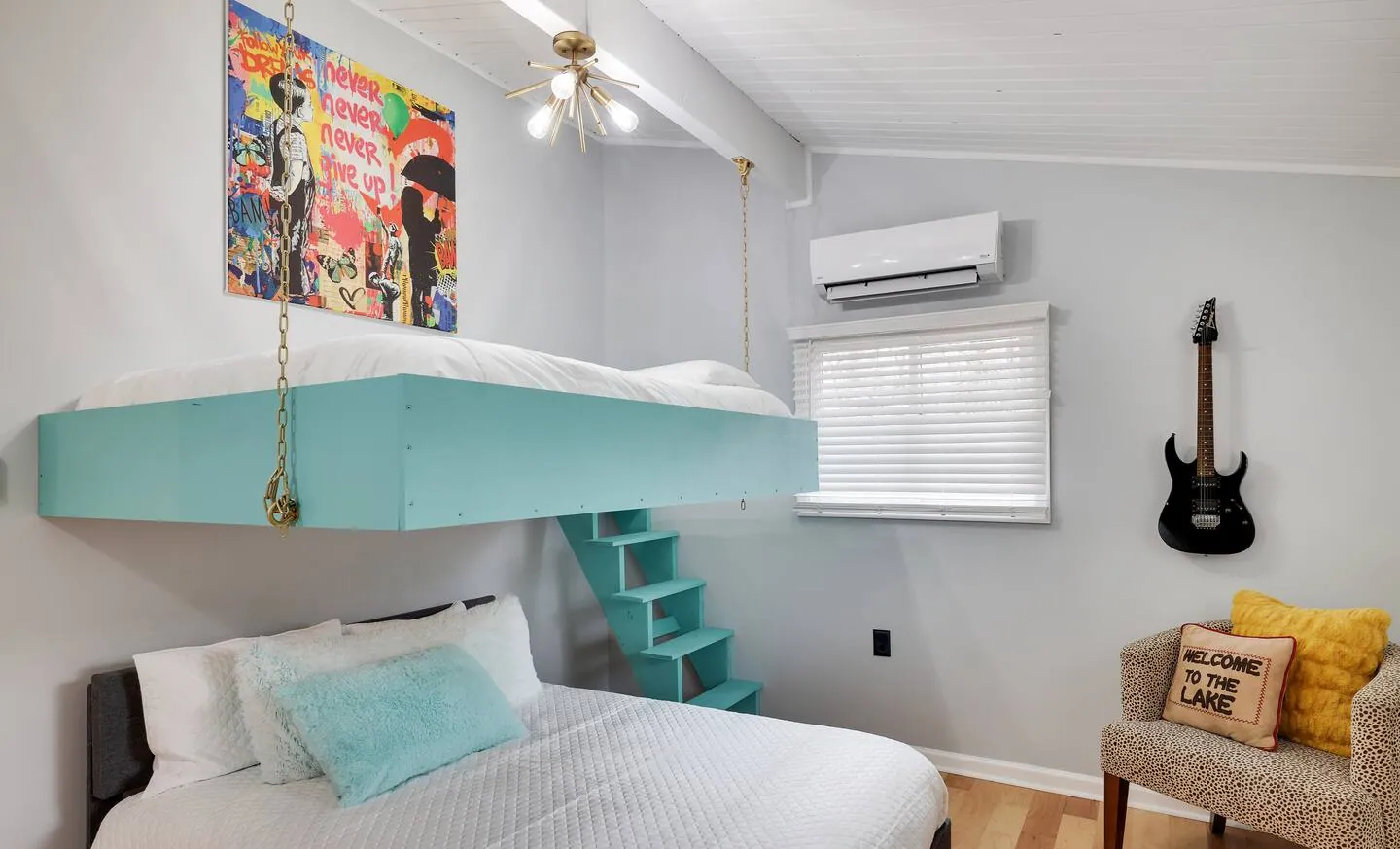 Guest bedroom with suspended full bed over a queen bed and teal steps at The Love Shack