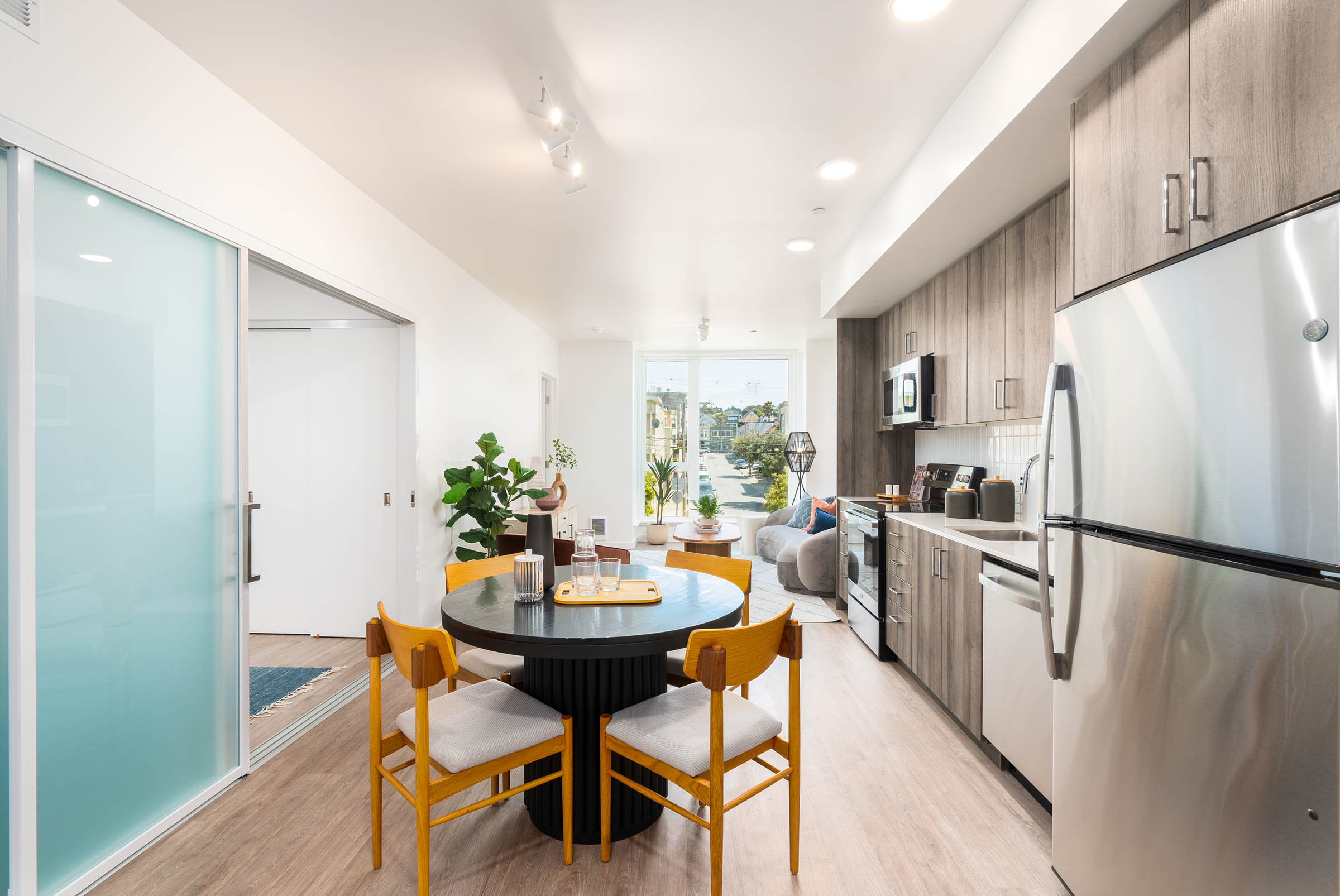Elegant residential structure showcasing large windows and outdoor spaces, set in a lush urban environment.