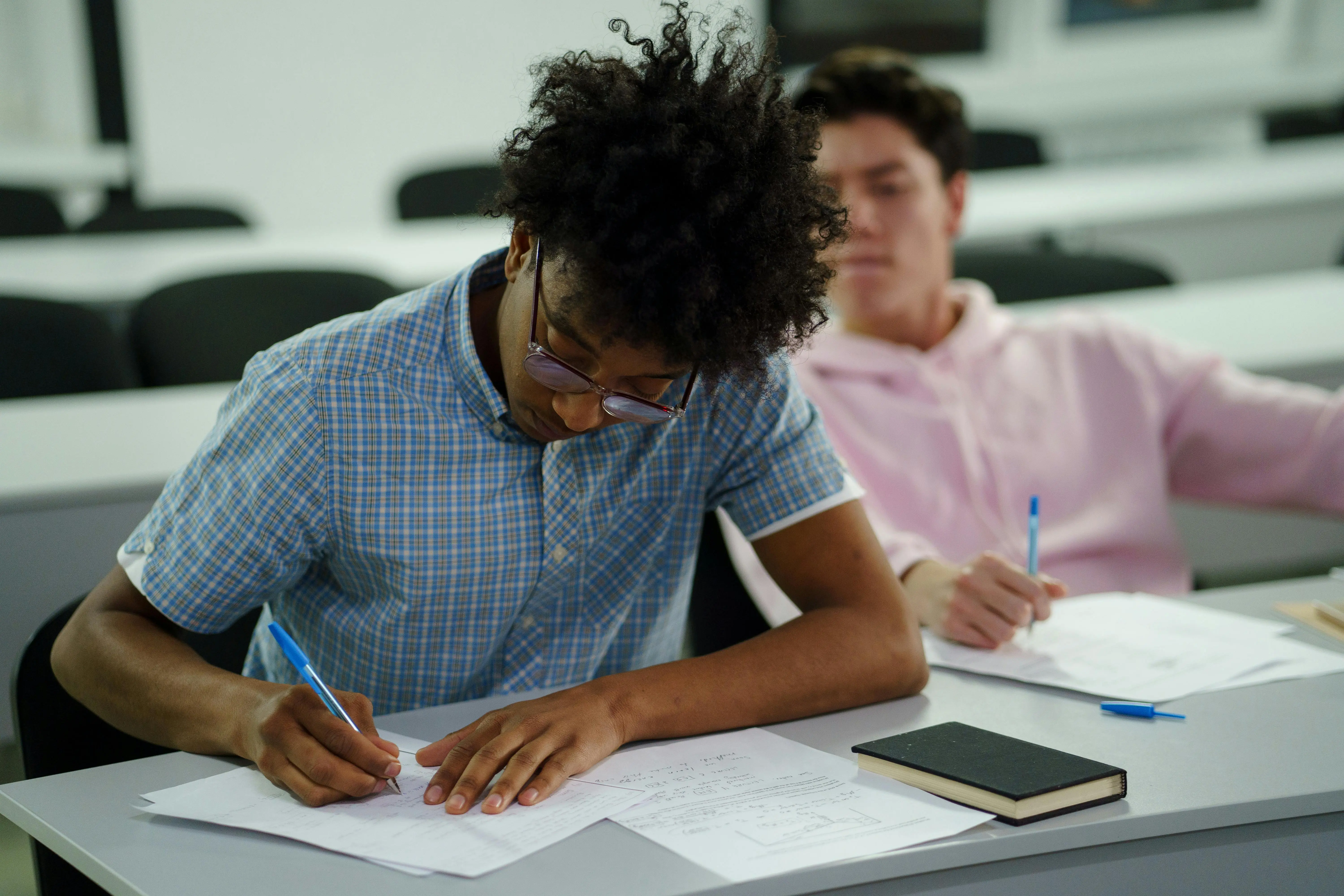 High school students writing in class during RISE summer programs for research, STEM, and Ivy League–mentored academic opportunities.