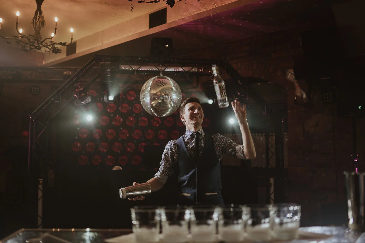 Atrakcje weselne – barman wykonuje pokaz barmański na mobilnym barze.