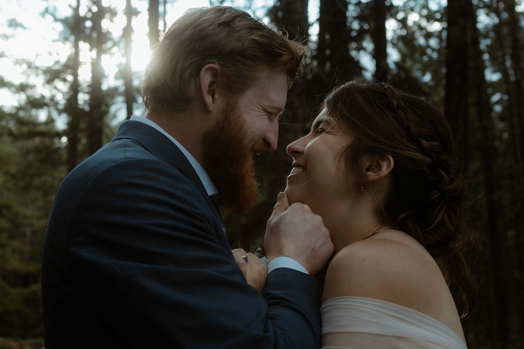 happy wedding couple laughing in forest