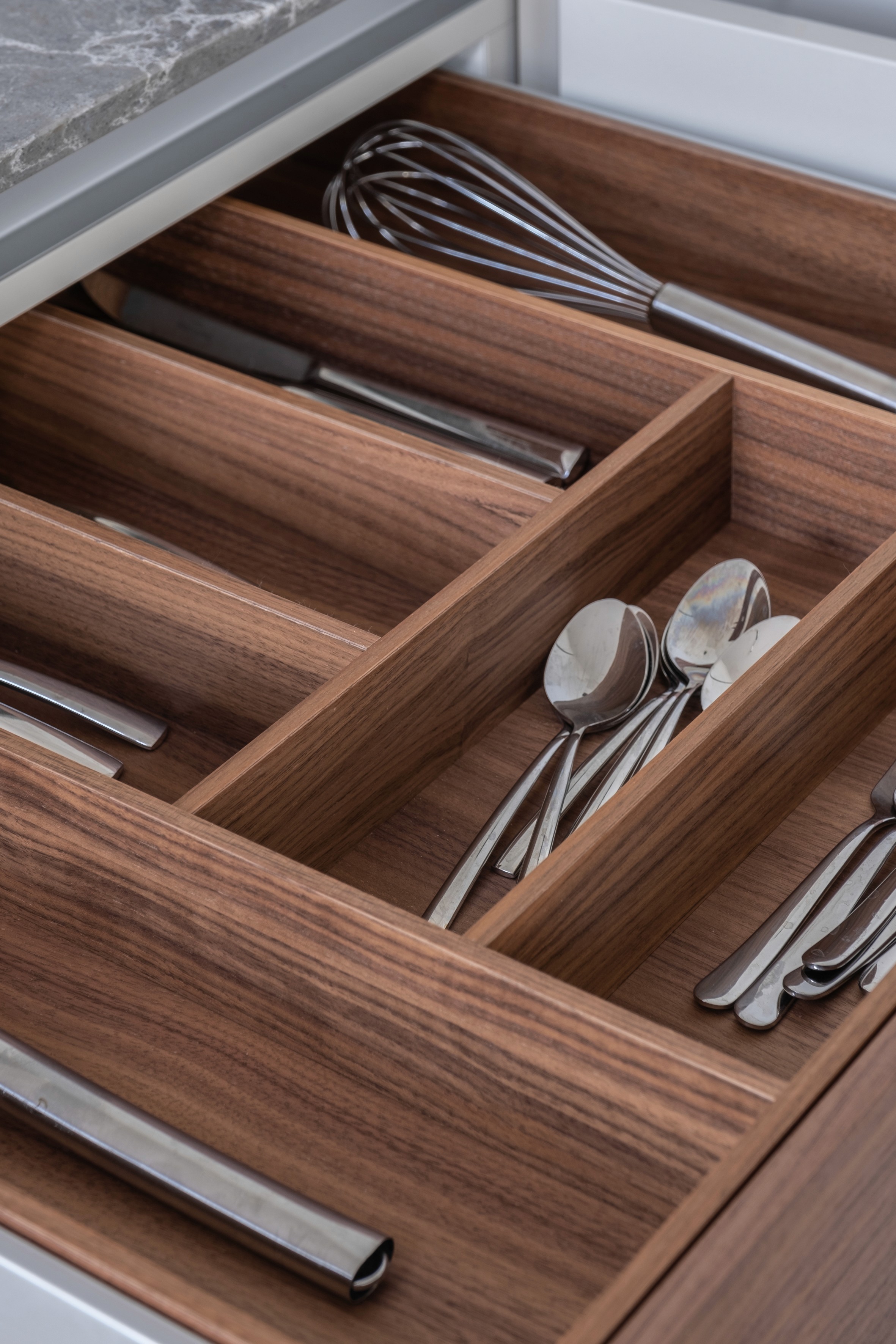 Custom walnut kitchen drawer organiser with whisks, knives, and utensils