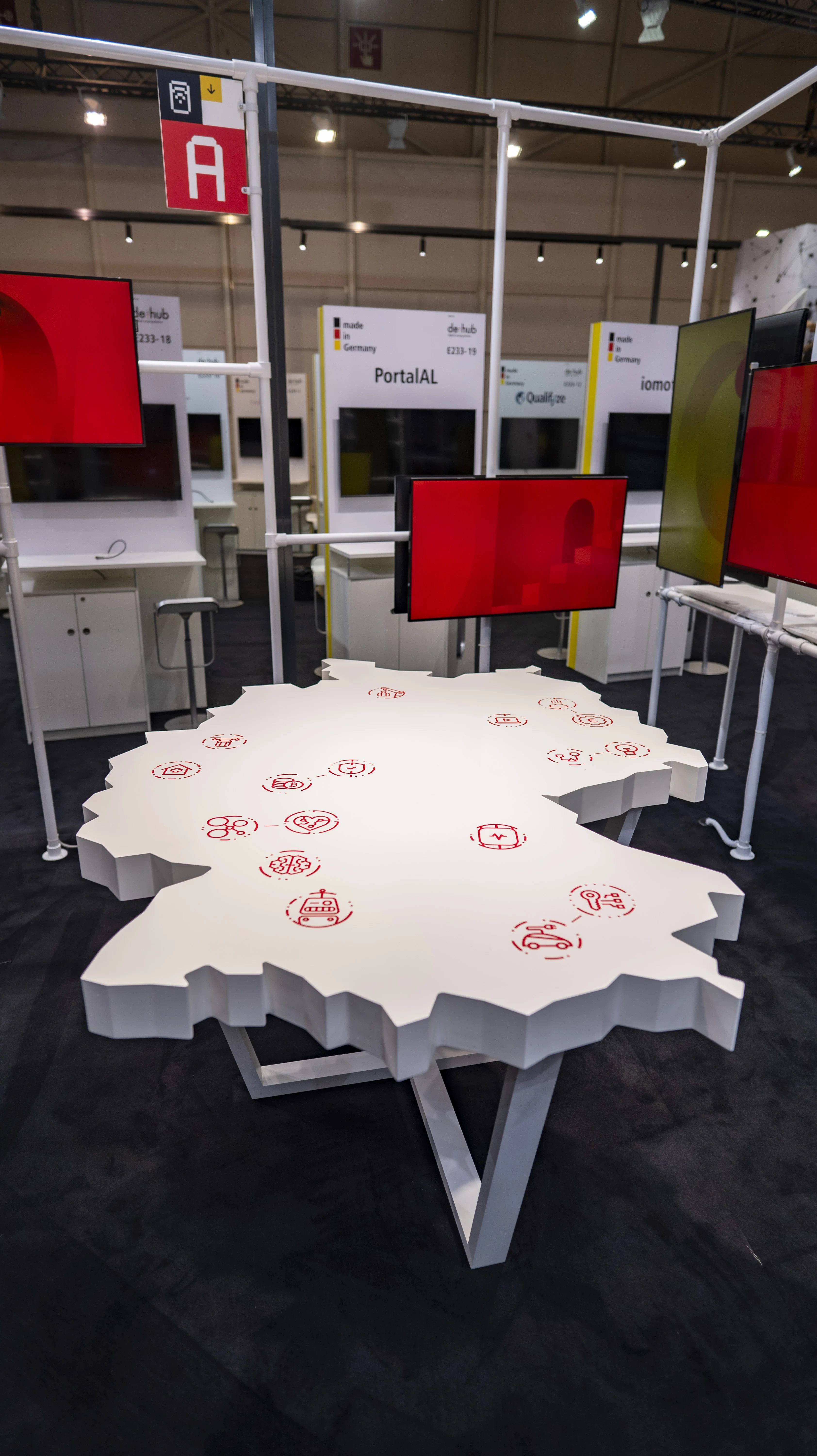 White table shaped like the map of Germany with red icons marking regions, at the German Pavilion at Web Summit.