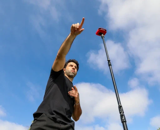Coach pointing to his players while you see a Reeplayer camera on a tall tripod in the background