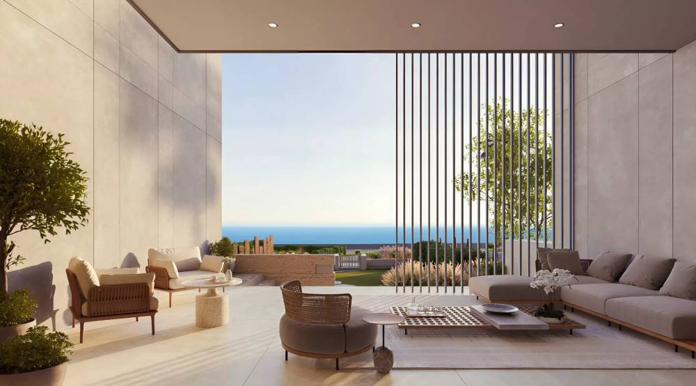 A serene view of a pool and palm trees with the ocean in the background, showcasing the beauty of ARIA by Beyond.