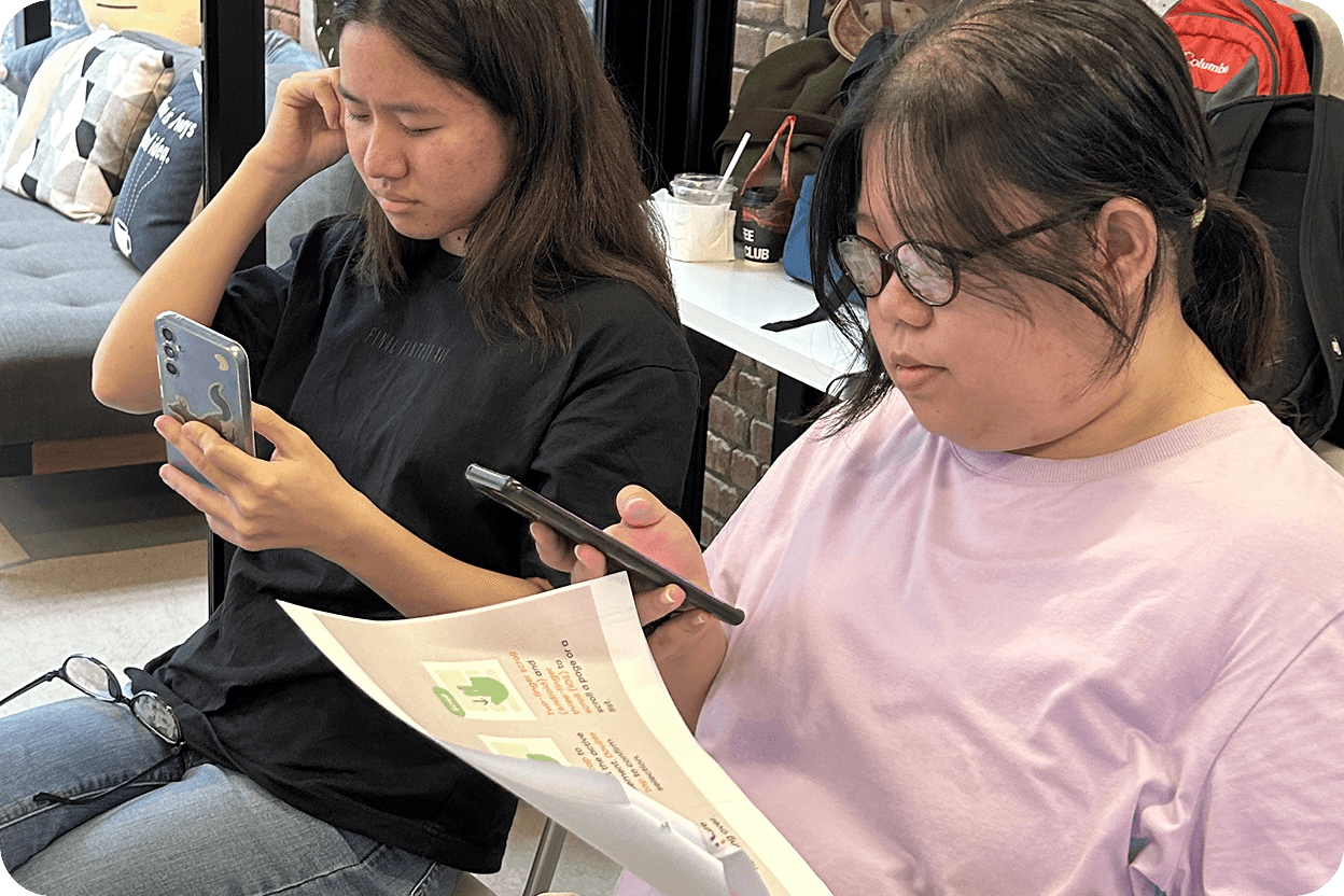 Two students looking at their mobile phones