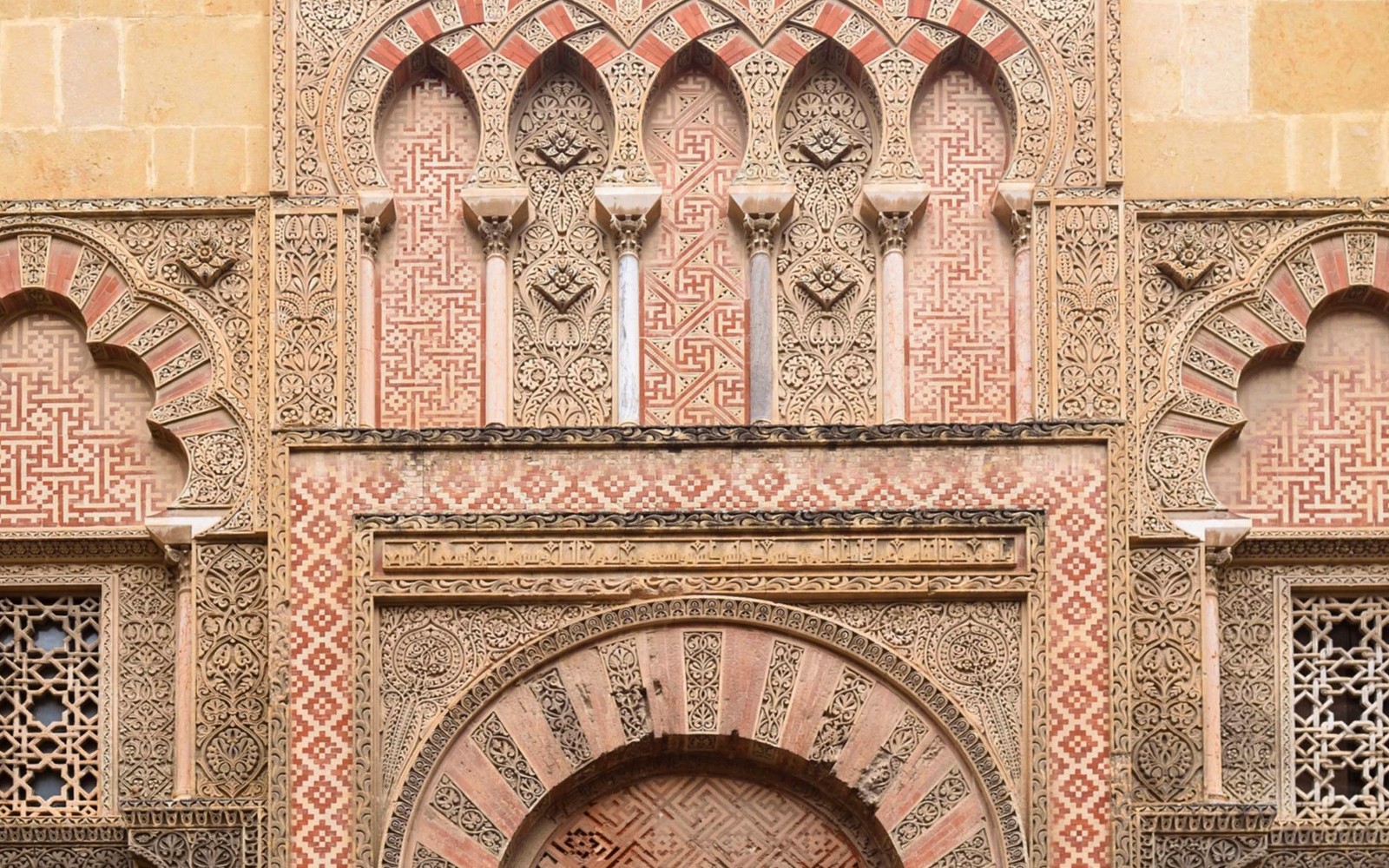 Side gate of Mezquita Cathedral in Cordoba with intricate Moorish designs.