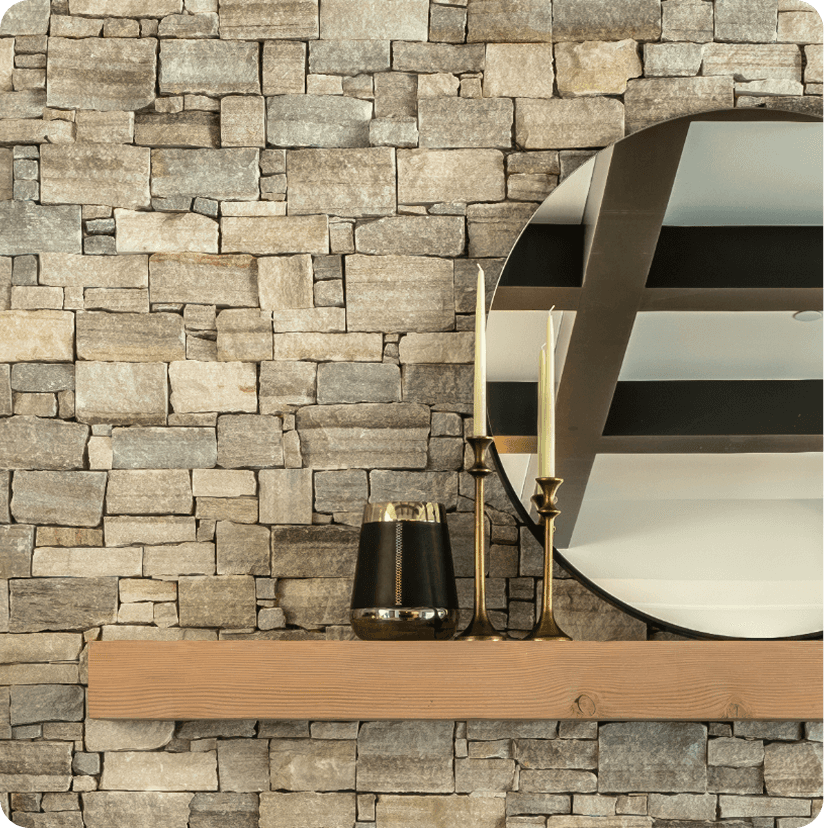 Natural stone accent wall with floating wood shelf, round mirror, and black decorative vase in modern sitting room