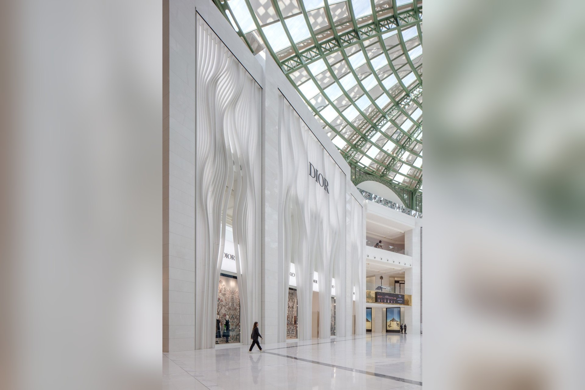 La façade blanche et ondulée de la boutique Dior, sous la verrière de Place Vendôme, à Lusail, un centre commercial où les grandes maisons ont ouvert leurs boutiques