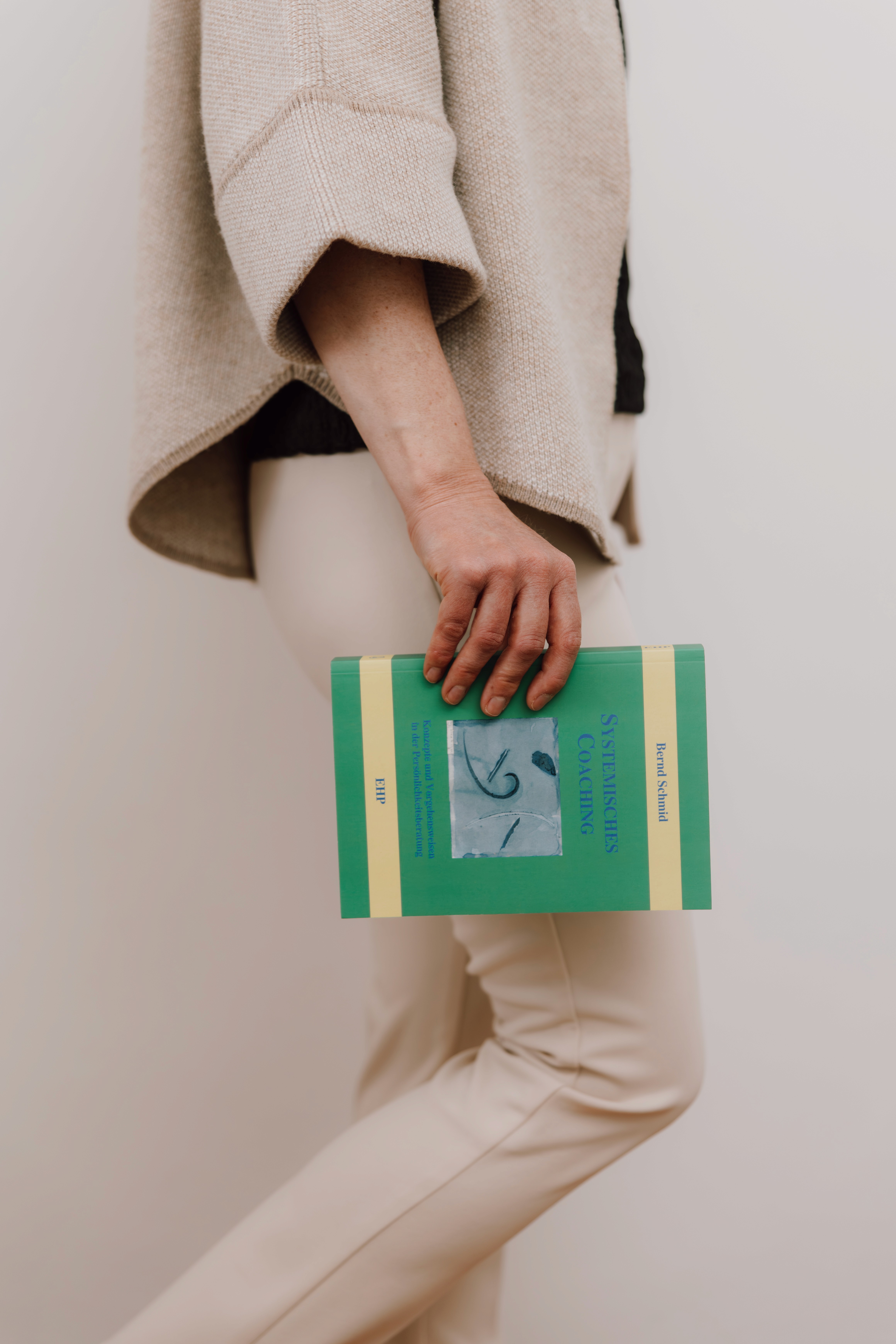 A circle of people sitting cross-legged, meditating with hands in a prayer position. Soft, warm lighting.