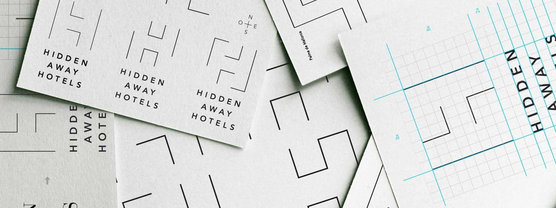 Tarjetas de presentación minimalistas de Hidden Away Hotels con diseño geométrico en papel texturizado.